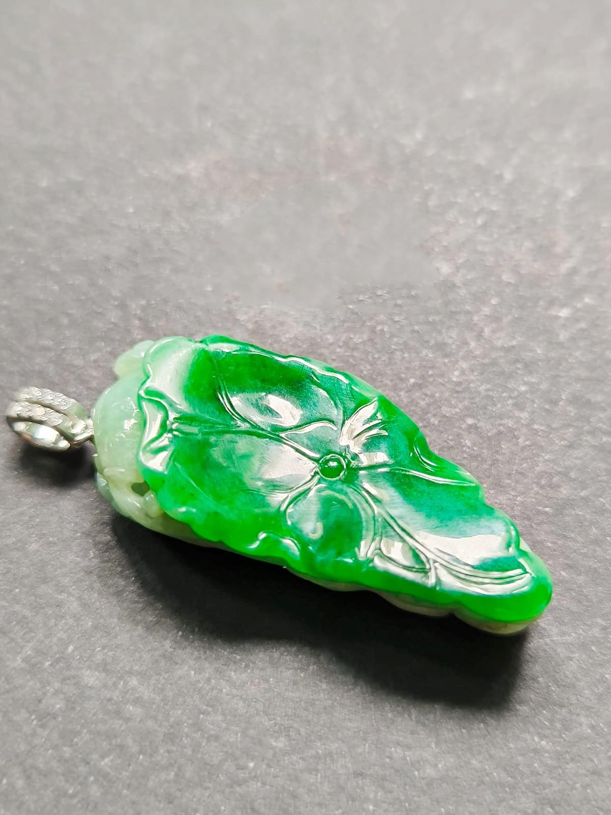 Découvrez la beauté époustouflante de ce pendentif en jade unique en son genre, réalisé avec les matériaux les plus nobles et une attention méticuleuse aux détails. Doté d'une superbe feuille de lotus en jade vert impérial, ce pendentif est un