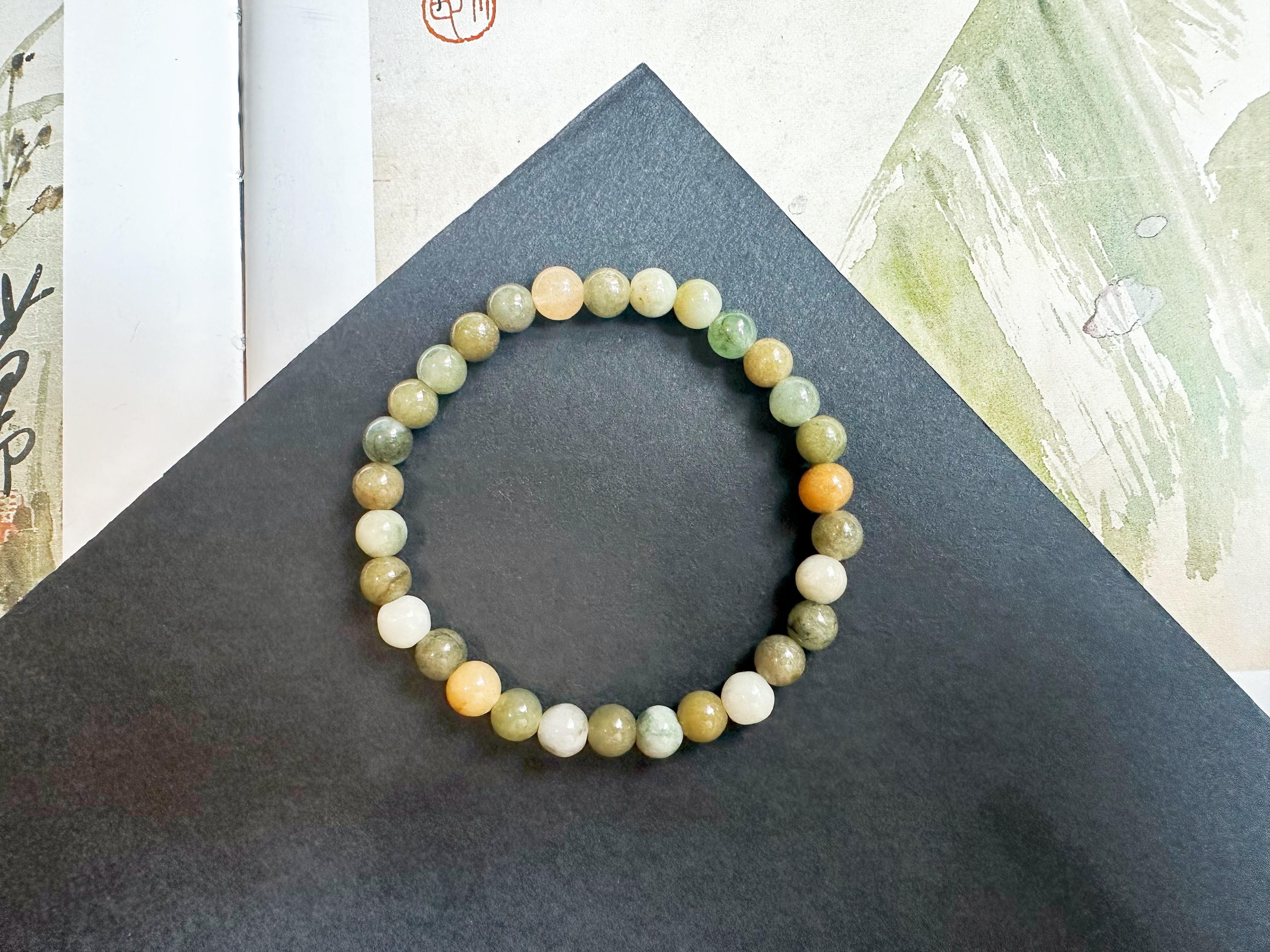 Scopri l'Eleganza con il nostro splendido bracciale di perle di giada, realizzato con 30 perle di giada naturale, non trattata e non tinta di tipo A proveniente dal Myanmar. Ogni perlina misura circa 6,1 - 6,6 mm di diametro e mostra la bellezza e