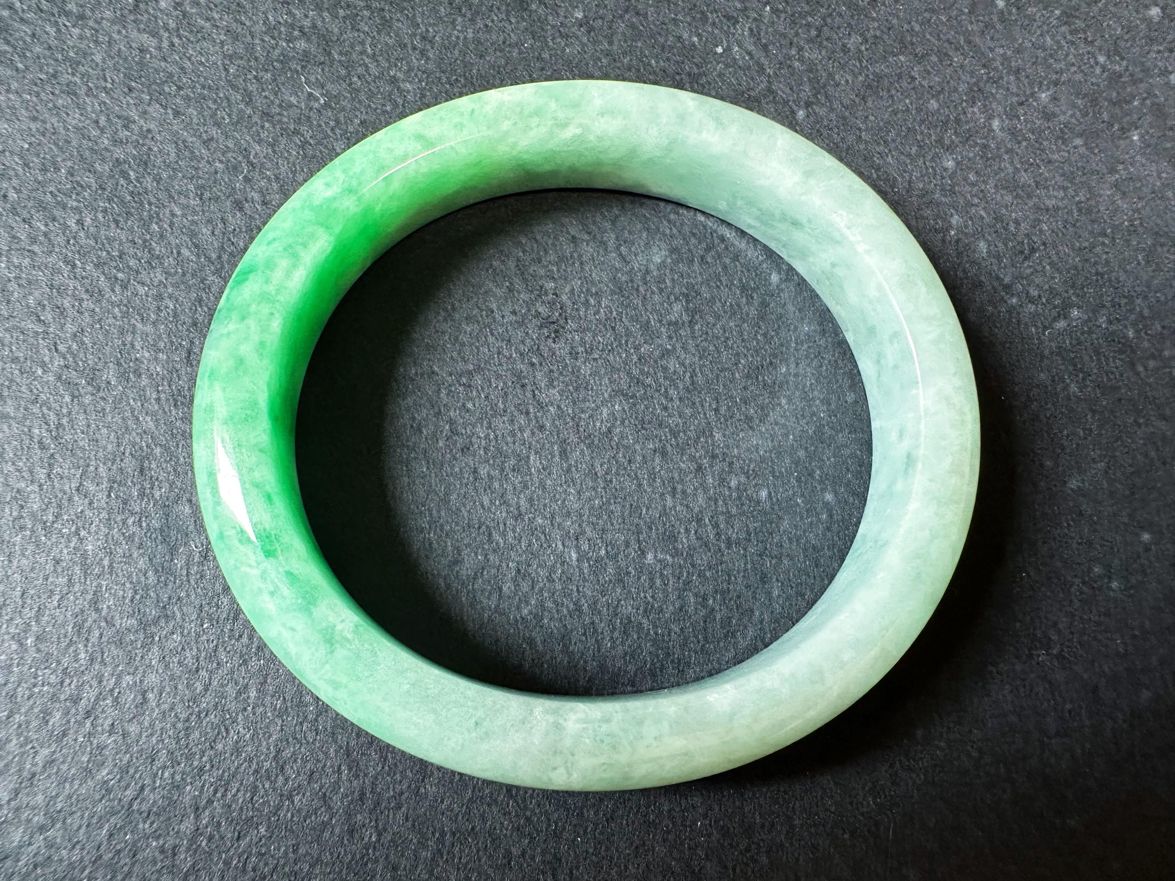 Experience the beauty of our stunning Myanmar jade bangle, crafted from 100% natural, untreated, and undyed Grade A jadeite. This exquisite bangle showcases a vivid apple green color, a gift from Mother Nature, making it truly unique and