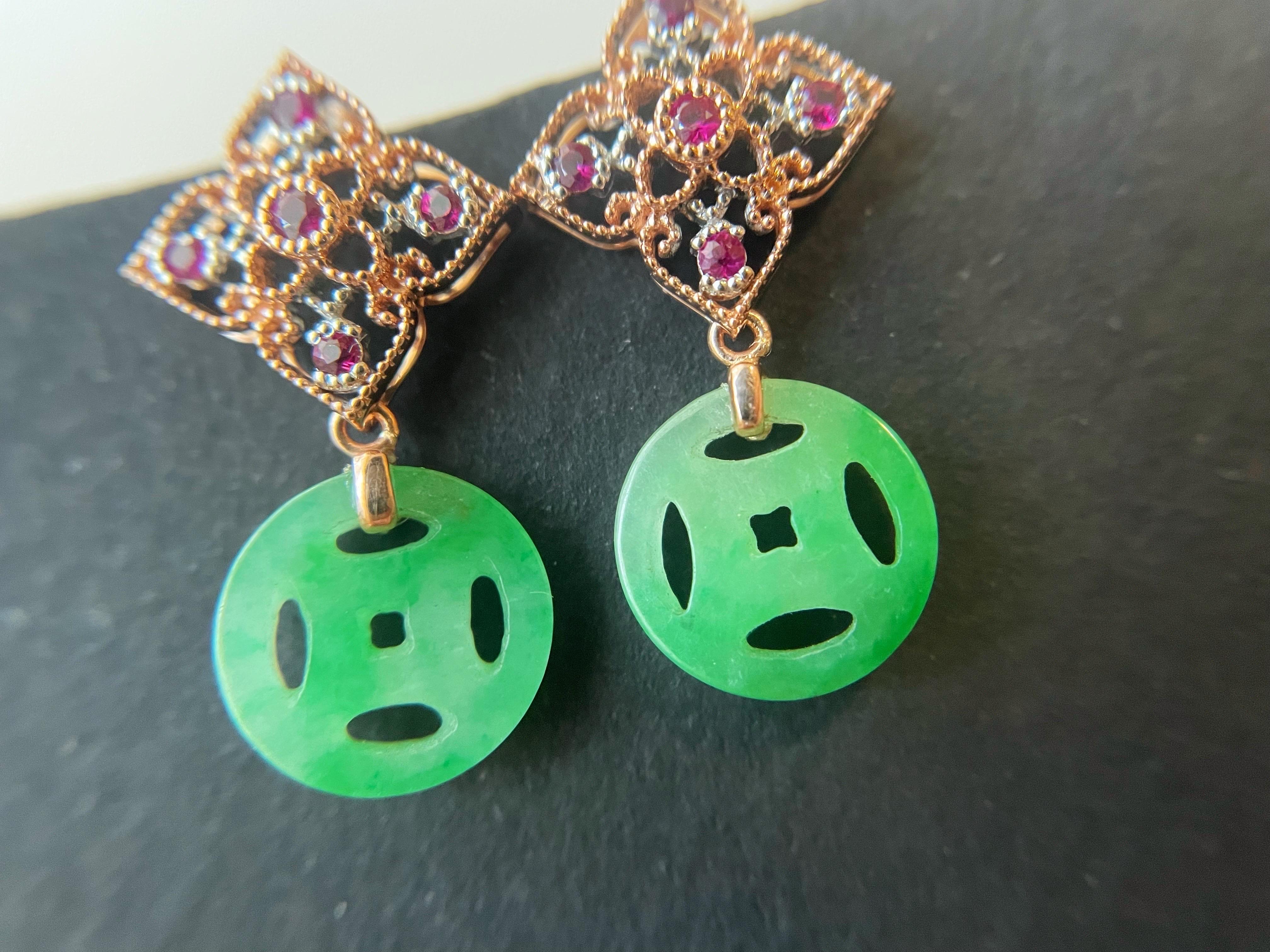 The custom-designed and handcrafted earrings are set with Myanmar vivid green jadeite in an ancient coin shape. These luxurious jadeite ear studs feature floral motifs and are embellished with vibrant rubies and high-quality diamonds.  It is simply