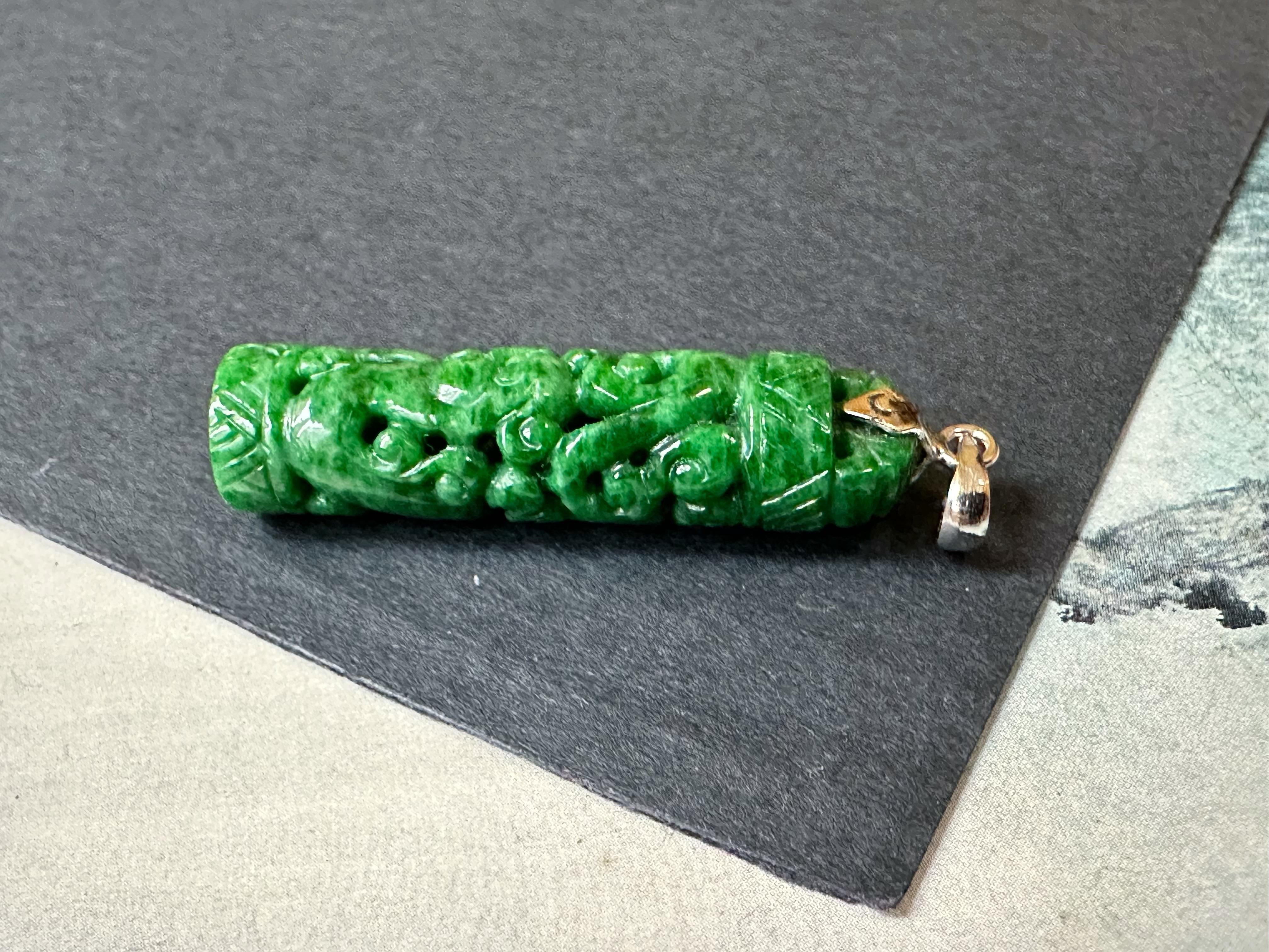 This jade pendant is 100% natural, untreated, and undyed Type-A Myanmar jadeite jade. It is pierce-carved into a cylindrical shape with dragon and phoenix patterns. The vivid green color Mother Nature gifted makes this pendant unique and attractive.