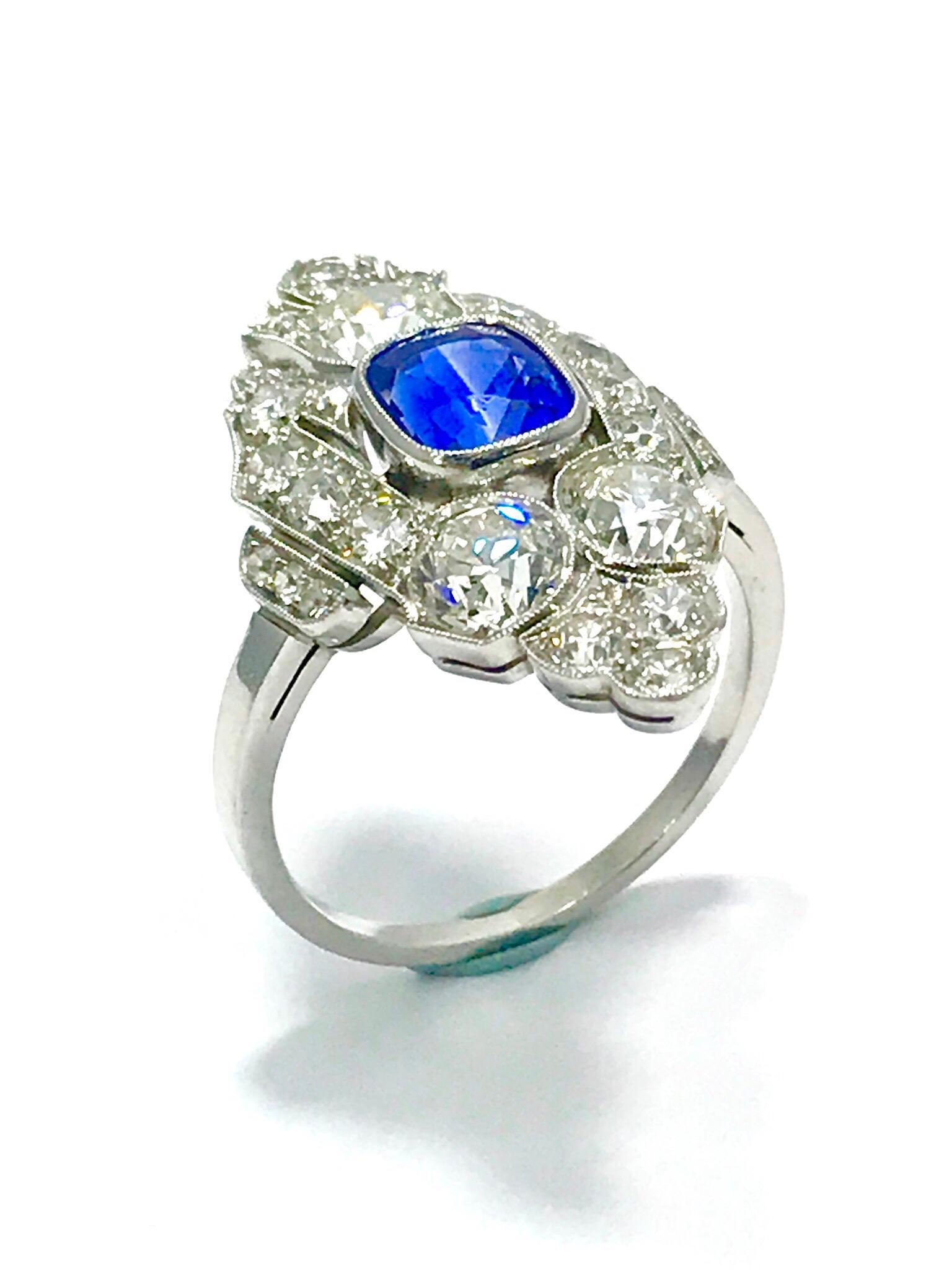 This is a stunning Art Deco Style natural no heat Sapphire and Diamond platinum ring.  The sapphire is cushion in shape, and bezel set with a milgrain edge.  It measures 6.90 x 5.80 x 4.90 millimeters, and weighs approximately 1.72 carats.  The