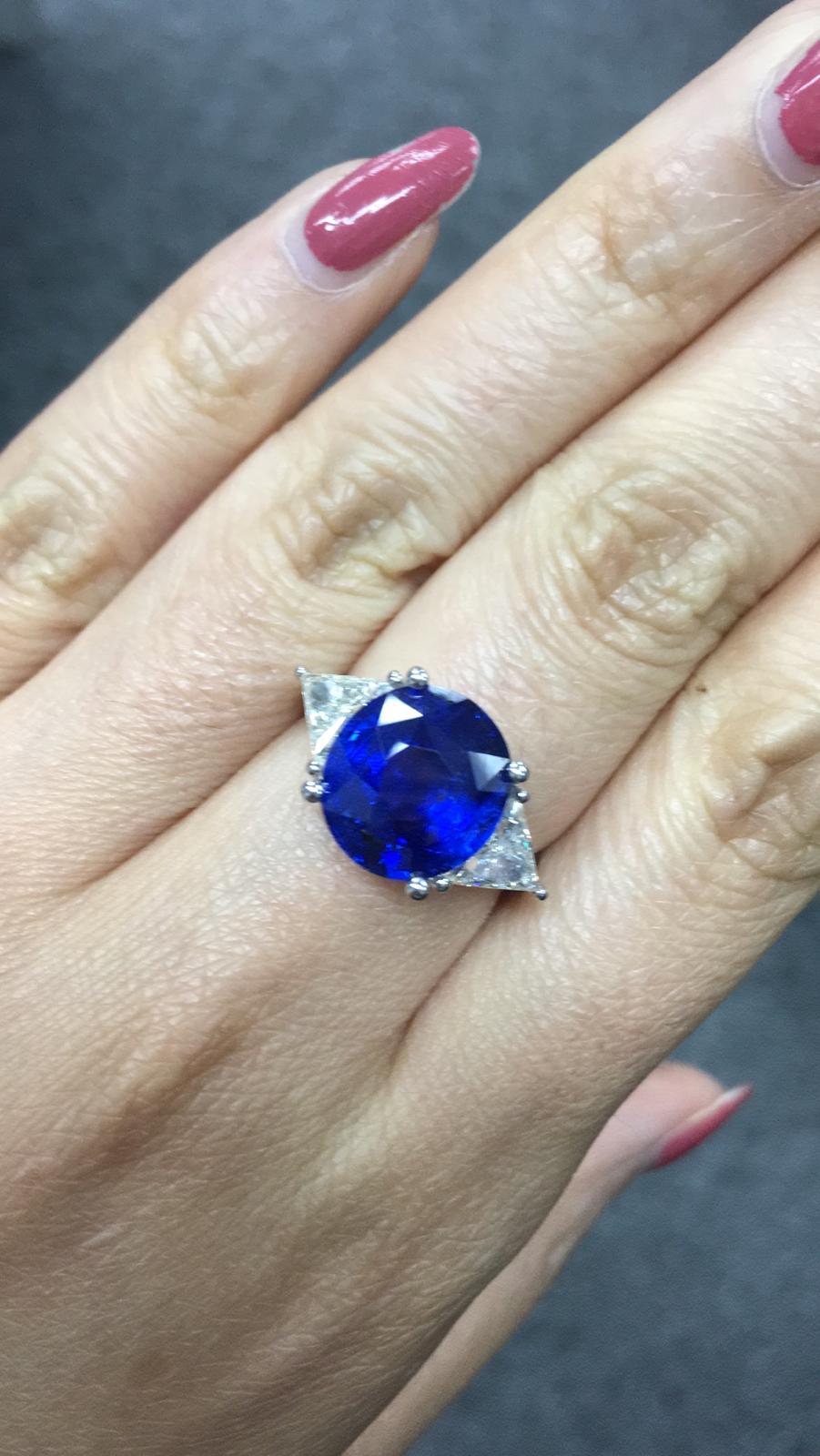 Primary Stone: Sapphire ( Sri Lanka )
Shape : Oval Cut
Sapphire Weight: 7.05 Carats 
Measurements Sapphire: 11.79mm x 10.83mm x 6.55mm
Color: Vivid Blue
Accent Stones: Genuine Diamond
Shape Or Cut Diamond: 2 Triangular Brilliants
Average