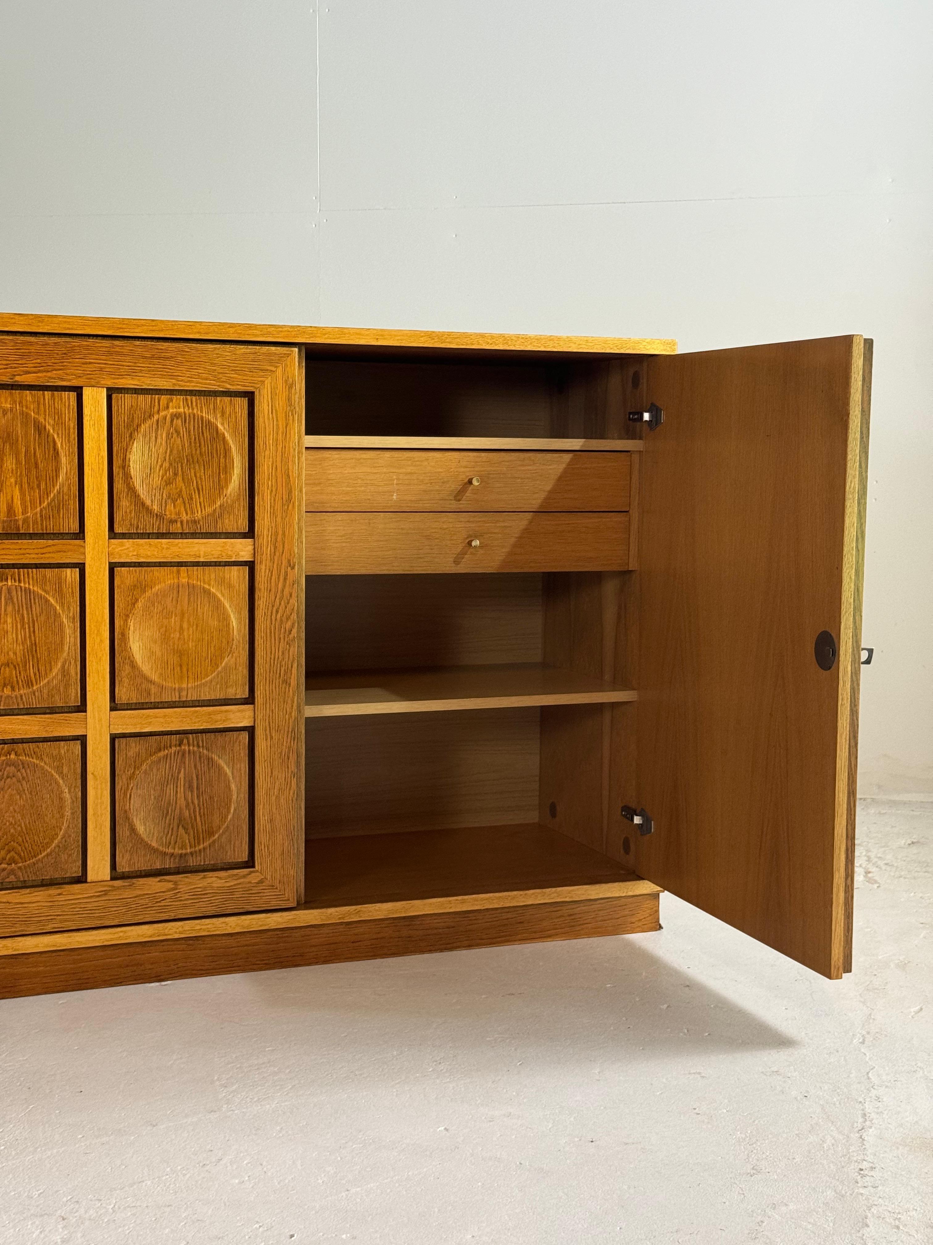 Amazing sideboard/credenza in natural oak wood with a nice grain in the wood.

4 round pattern doors with inside lots of storage space.

In absolute perfect, refinished condition, 3 keys available.

Dimensions

Height 88cm

Depth 45cm

Width 230cm