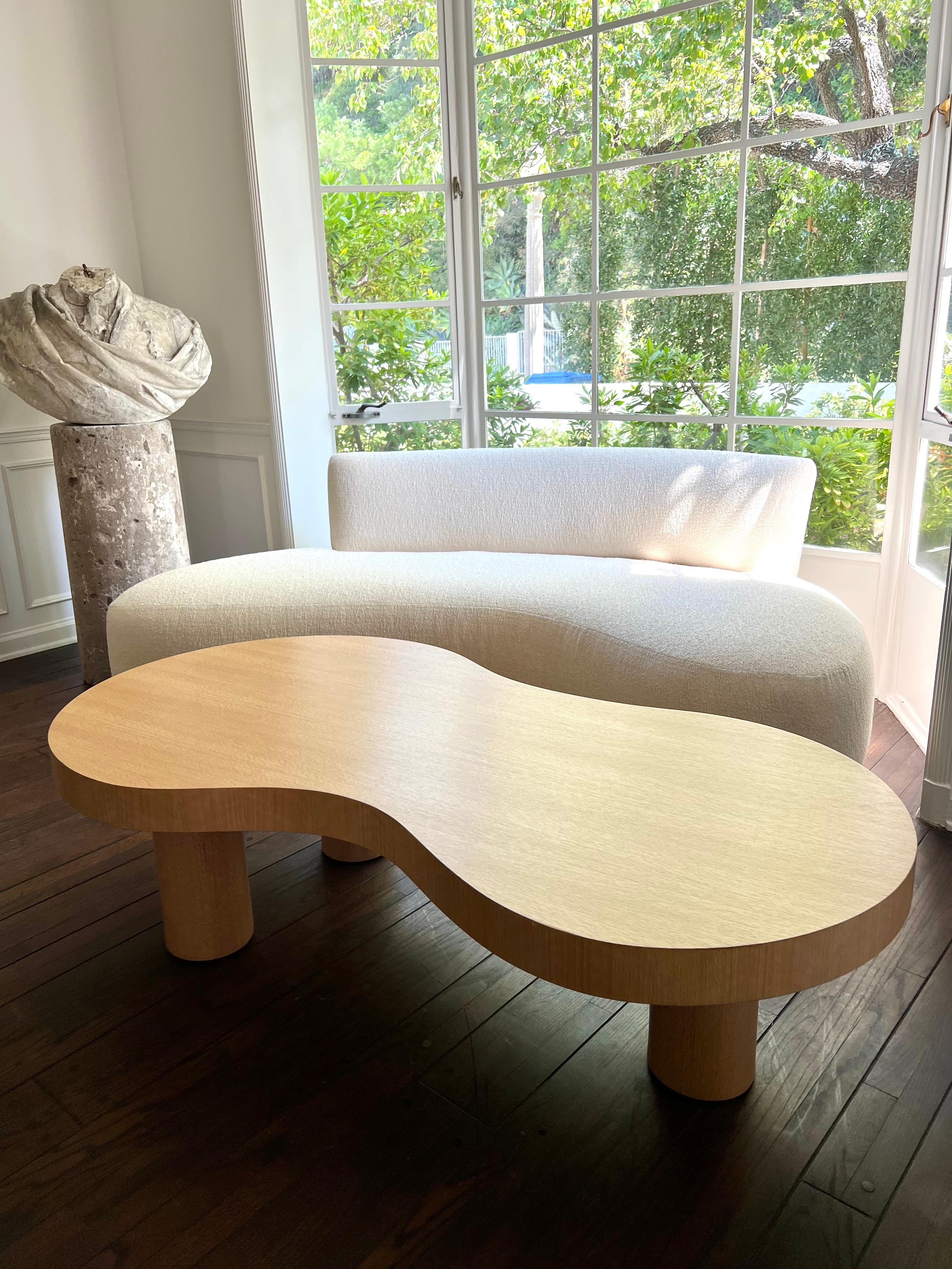 Custom white oak coffee table with natural finish and tripod cylinder legs.