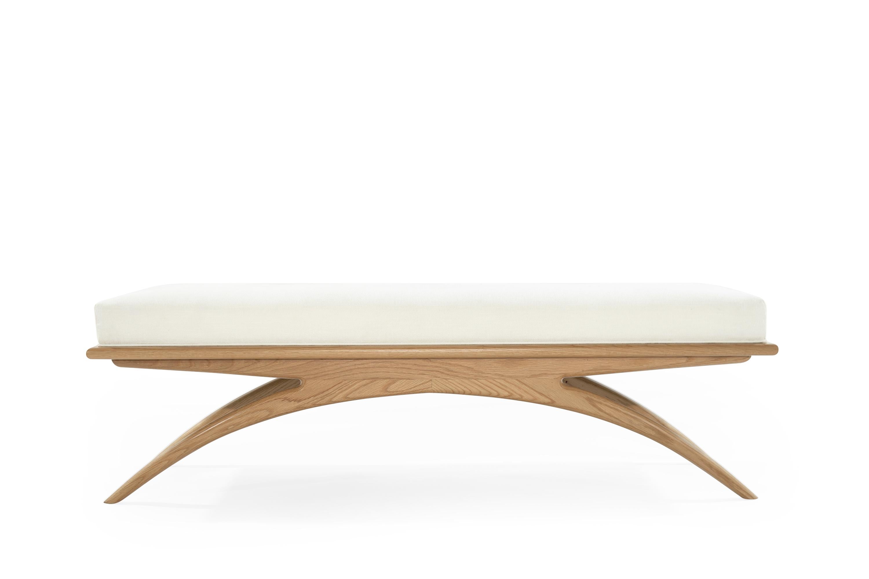 Artfully balanced. This handcrafted bench has a lightweight aesthetic with solid construction. The prim, rectangular cushion is beautifully upholstered in linen, resting delicately on a solid oak base. Elevate your space with sloping curves inspired