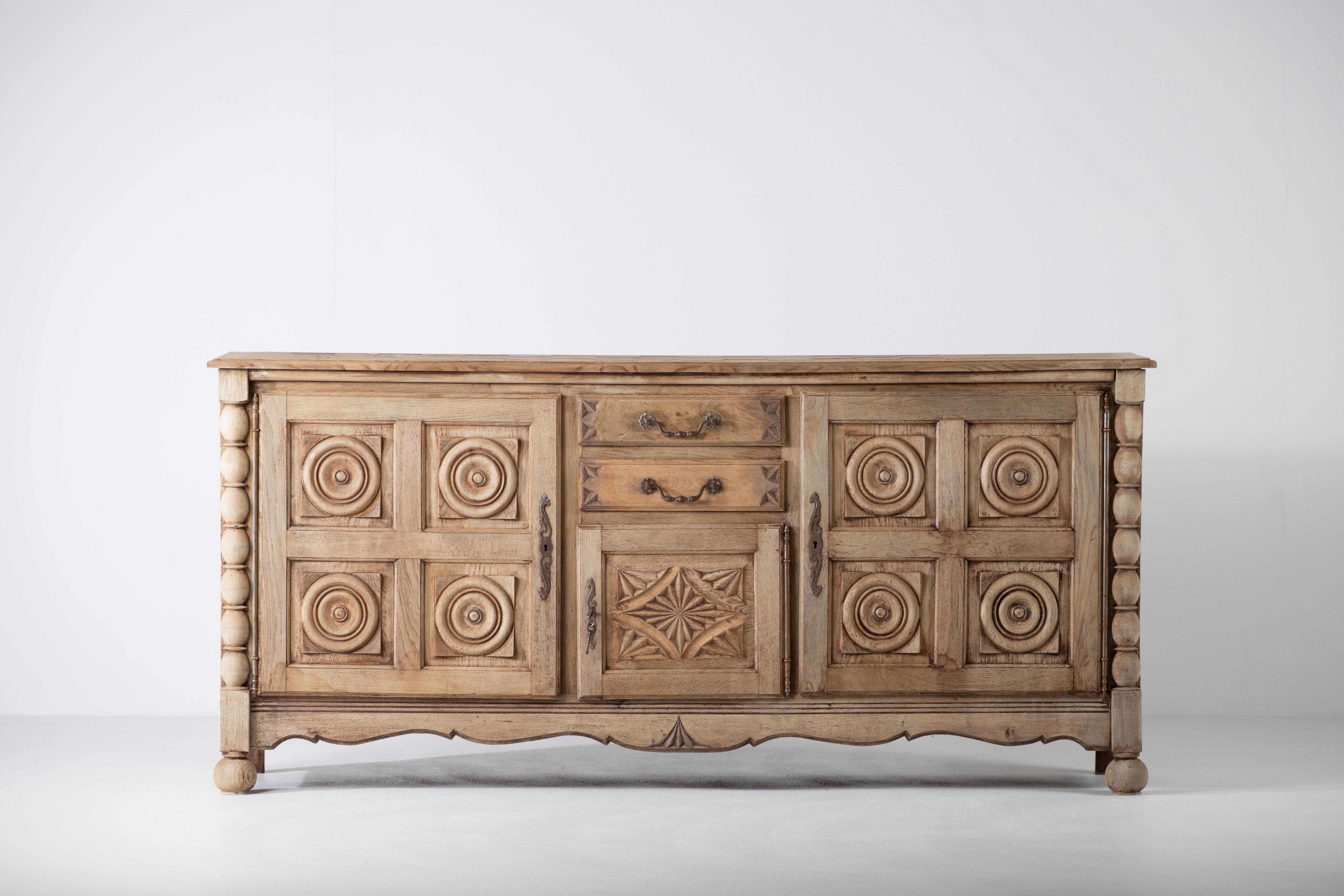 Unearthed in Normandy, this Breton style piece of furniture in solid oak will bring a touch of authenticity to an interior.
The sideboard consists of two compartments with shelves whose doors are covered with circular patterns typical of the