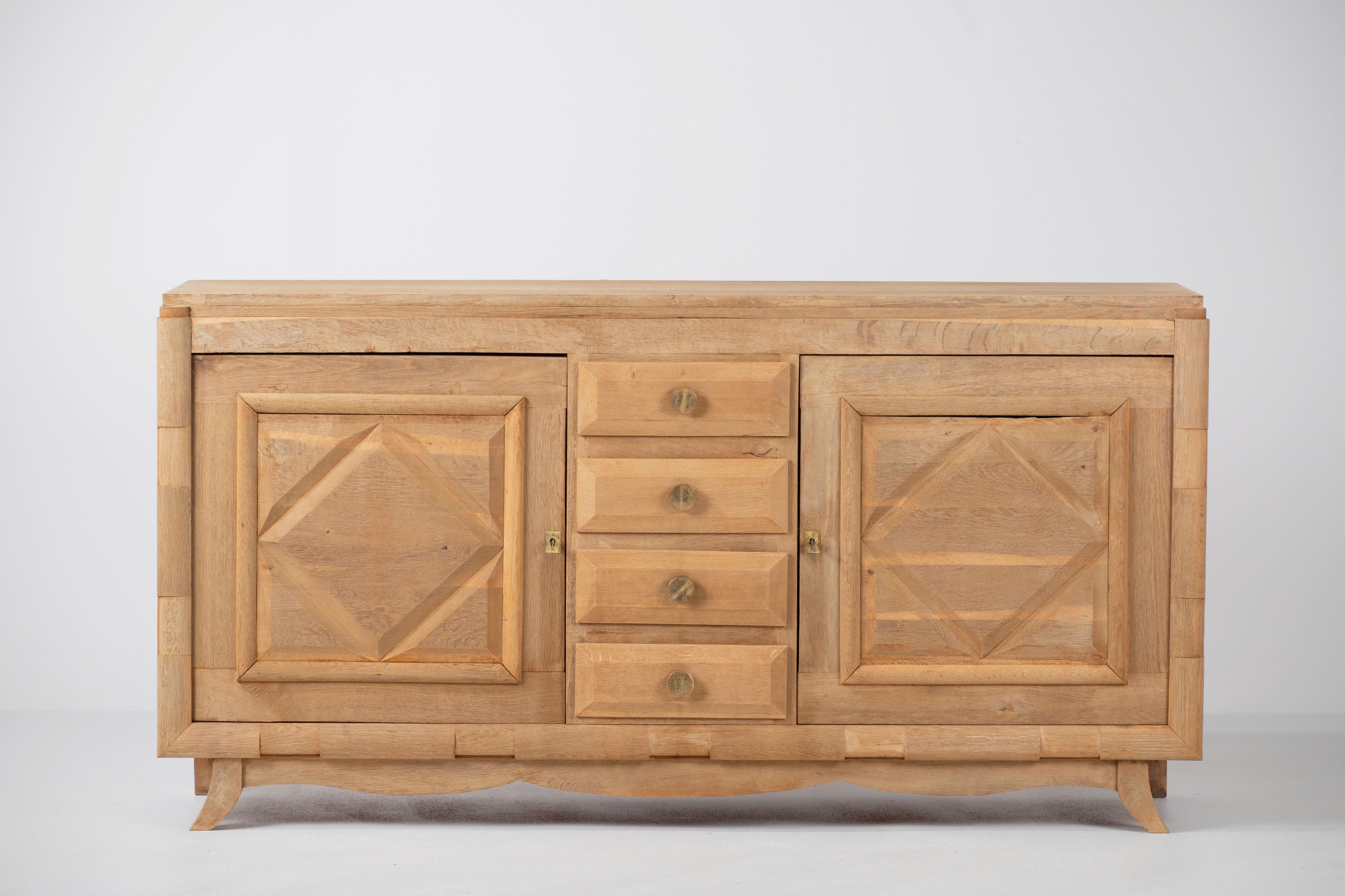 Natural Oak credenza, France, 1940s 
The sideboard consists of two compartments with shelves whose doors are covered with graphical patterns and four drawers.
Good condition.
 