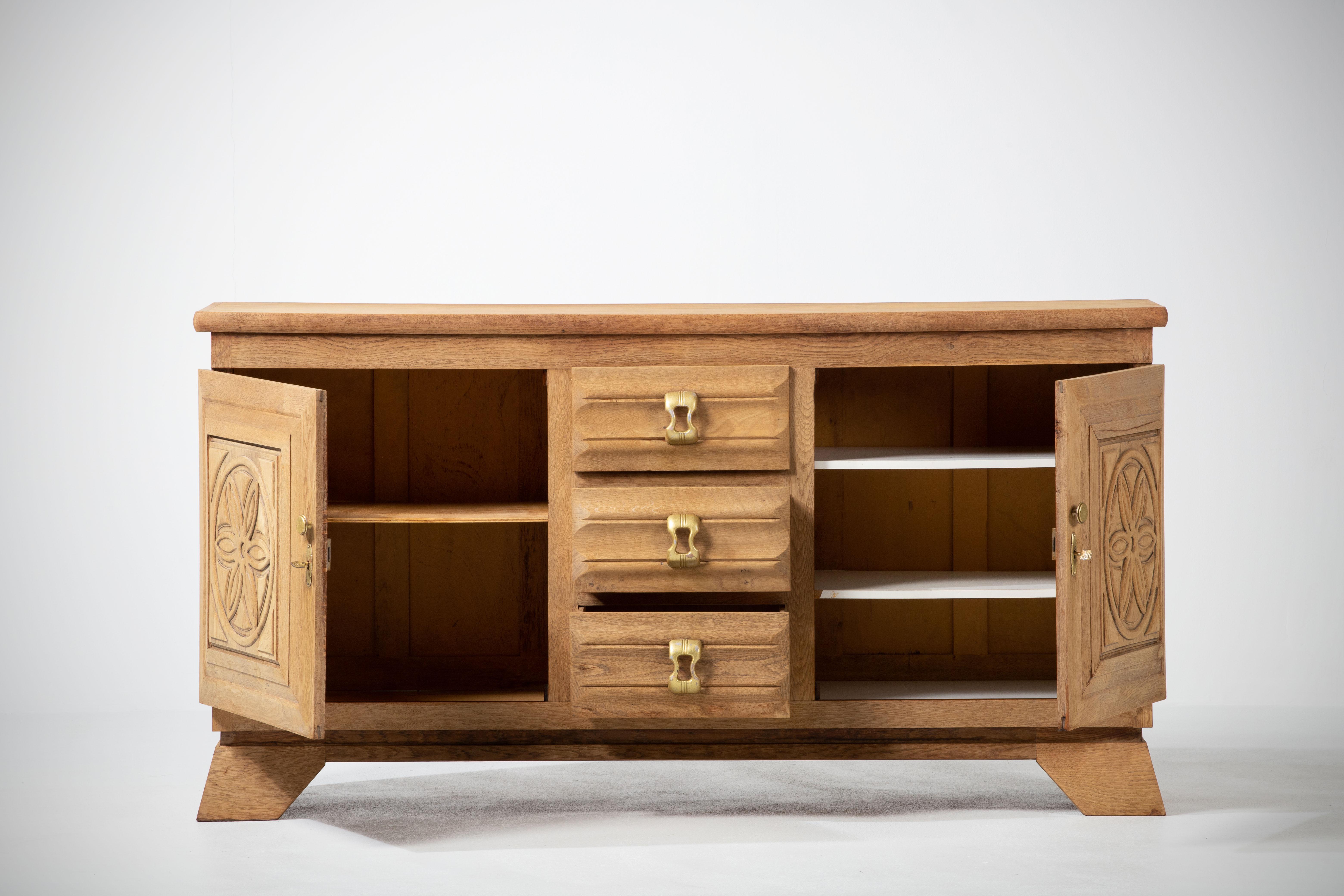 Natural Oak credenza, France, 1940s 
The sideboard consists of two compartments with shelves whose doors are covered with graphical patterns and three drawers.
Good condition.
 