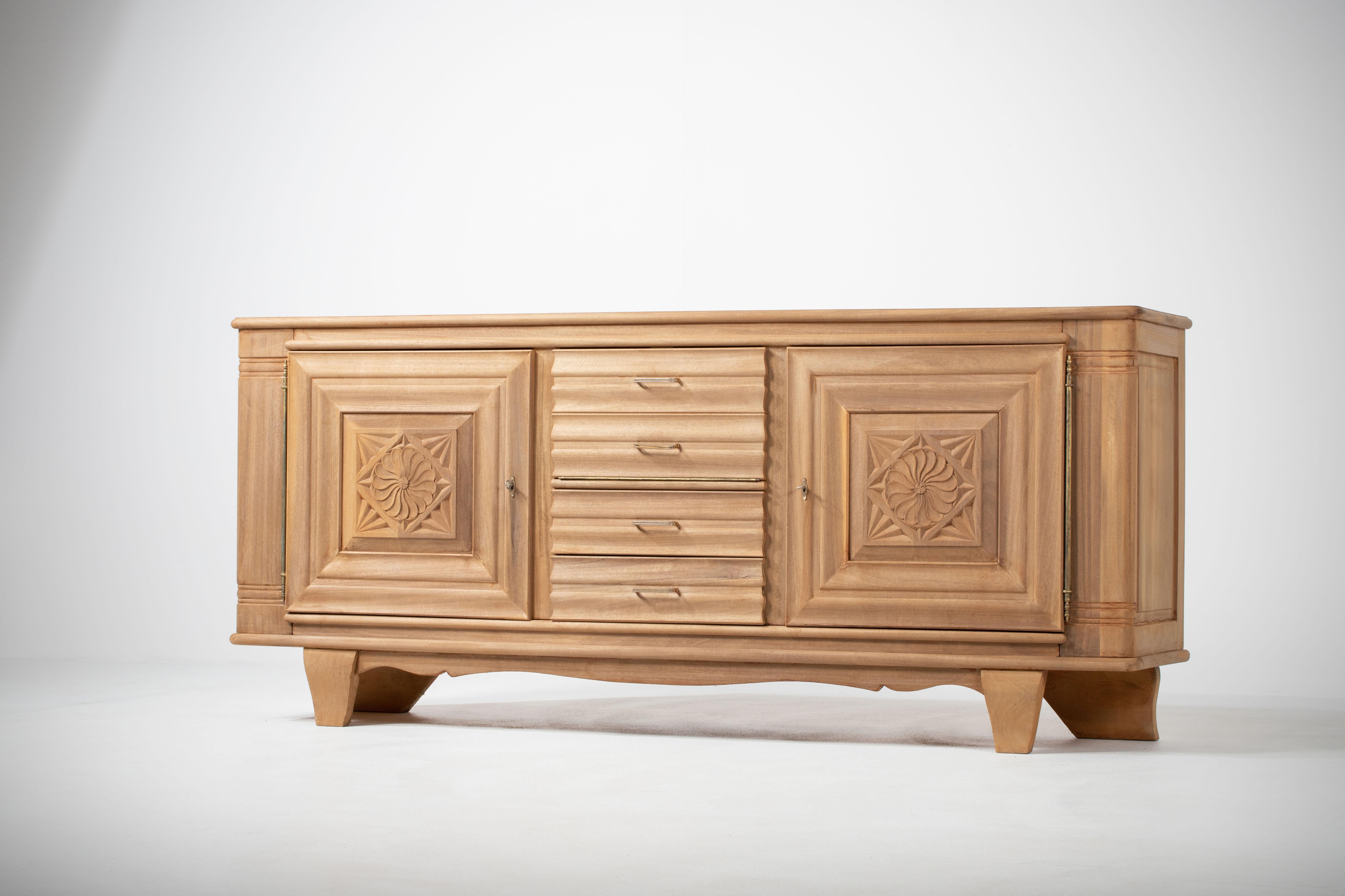 Crédence en chêne naturel, France, années 1940 
Le buffet est composé de deux compartiments avec des étagères dont les portes sont recouvertes de motifs graphiques et de quatre tiroirs.
Bon état.
 