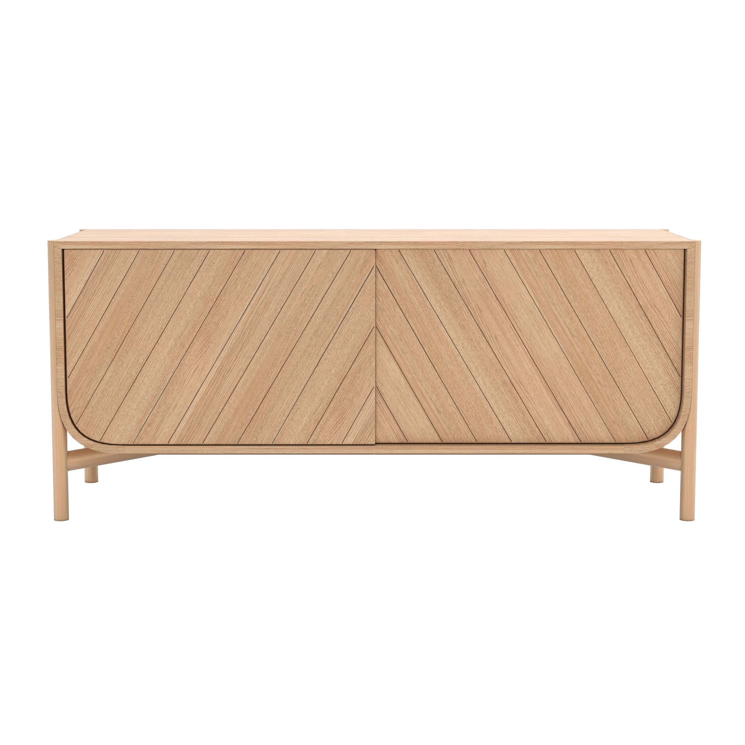 Natural Oak Marius Sideboard by HARTO
Dimensions: W 155 x D 45 x H 65 cm. 
Materials: Solid Wood, MDF wood veneer.  
Weight: 51.0 kg

The 155cm sideboard from the Marius collection is undeniably elegant, with its sliding doors engraved with oblique