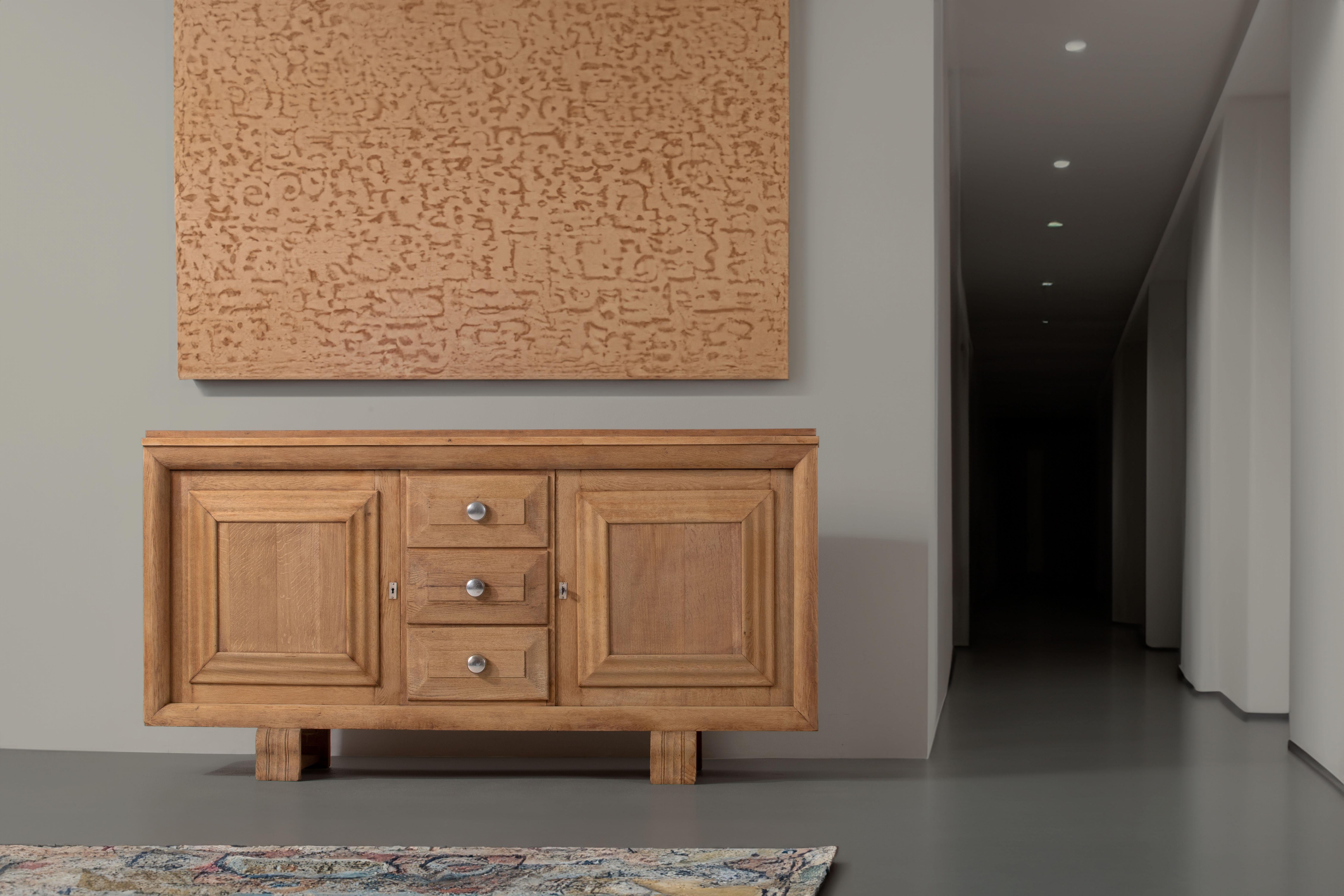 Introducing an exquisite Art Deco buffet in natural oak, crafted in the style of the renowned French furniture designer, Charles Dudouyt. Dudouyt's work is celebrated for its exceptional craftsmanship, innovative designs, and seamless blend of