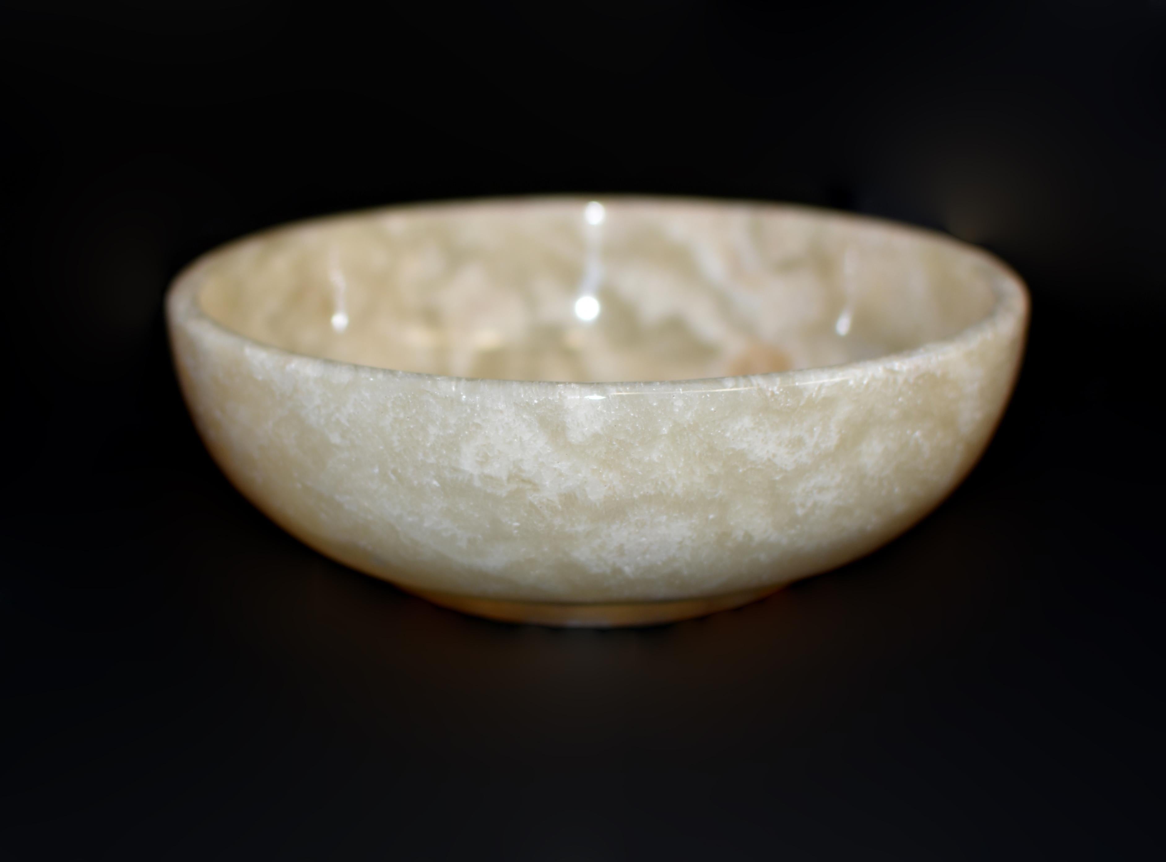 Cette étonnante coupe ronde de 8 pouces témoigne de la beauté de la pierre naturelle. Fabriqué en onyx massif de qualité supérieure, il présente un jeu captivant de teintes crème, perle, or et rouille. Les veines complexes de la pierre confèrent un