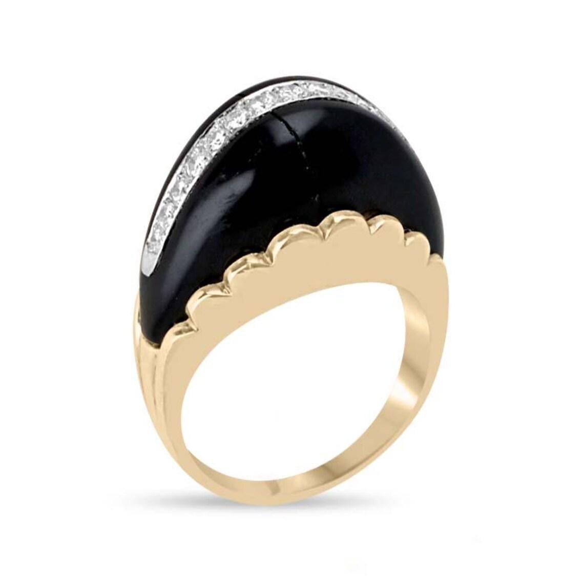 Este anillo de inspiración vintage con acento de ónix y diamantes muestra una llamativa pieza central de ónix, adornada con una hilera de brillantes diamantes de talla redonda en su centro para lograr un cautivador contraste. El ónice se sujeta