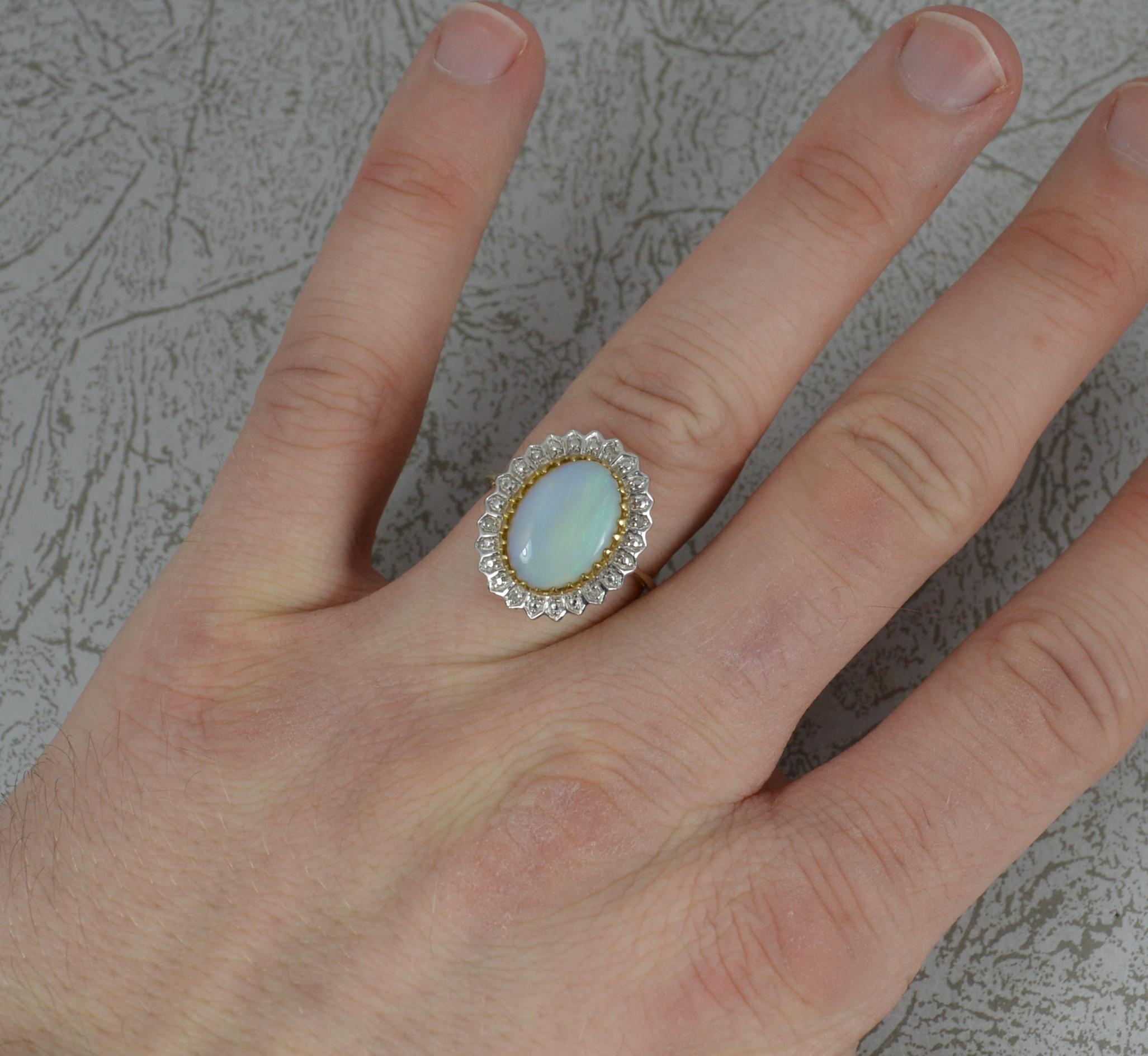 A fine quality opal, diamond and 9ct gold ring.
9 carat yellow gold head and white gold shank.
Set with an oval opal, 9mm x 13mm approx. Surrounding are small natural round cut diamonds. 15mm x 19mm cluster head.
Simple yet stylish