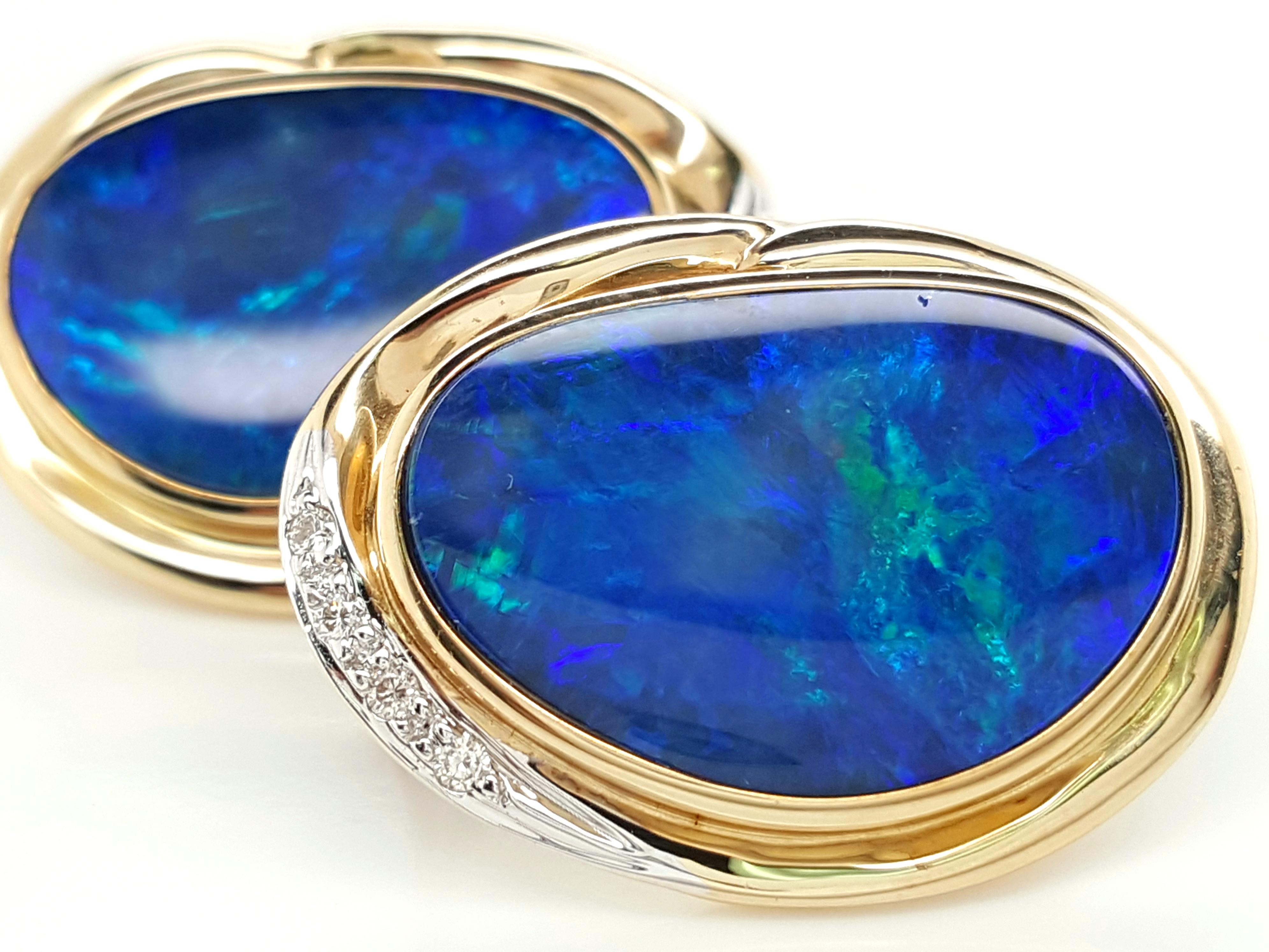 These large sized opal earrings look as if they walked directly out of the 80's. The stunning and complimentary look of natural blue opals set in yellow gold is such a fun vintage style. Each earring centers around a big flat oval natural opal