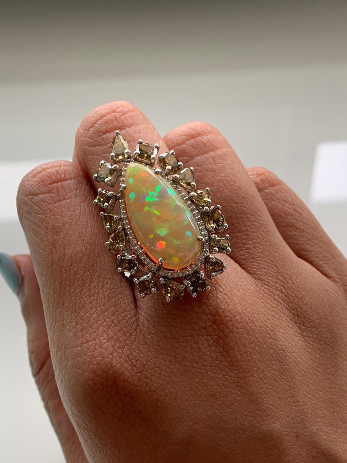 A modern cocktail ring set in 18k white gold with Ethiopian natural opal and natural fancy colour diamonds. The opal weight is 7.72 carats and diamond weight is 4.7 carats. The net gold weight is 8.29 grams and ring dimensions in cm 3.4 x 2 x 2.5