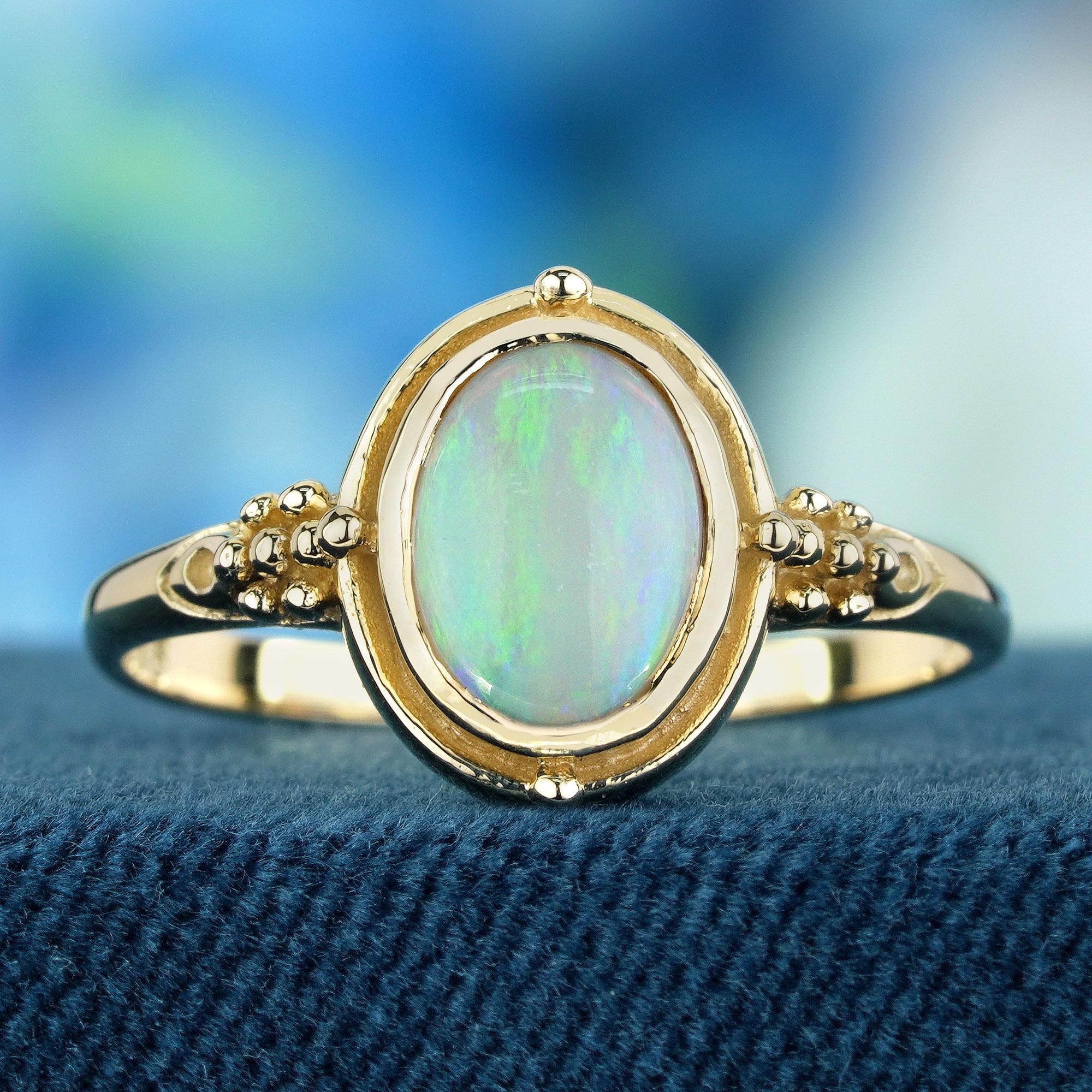Cette bague captivante incarne la grâce vintage avec une opale blanche naturelle nichée dans un chaton sécurisé sur un anneau fin et délicat en or jaune pour évoquer une sensation classique et intemporelle et ajouter une touche de féminité et
