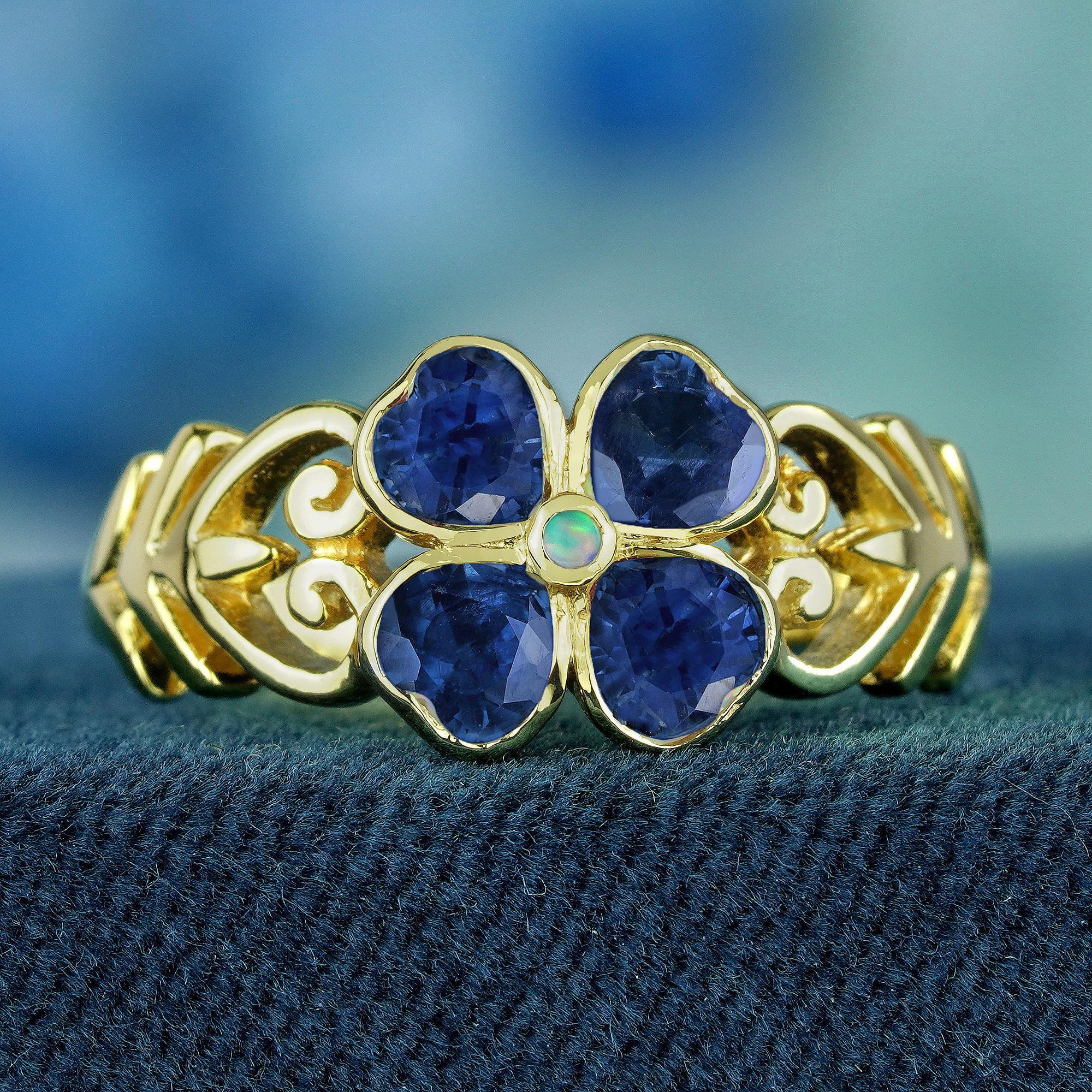 This Natural Opal Blue Sapphire Vintage Style Floral Ring is a timeless masterpiece, featuring a radiant Natural Opal at its center that shifts in vibrant colors. Surrounded by rich Blue Sapphires, it evokes the calm beauty of a starlit sky. The