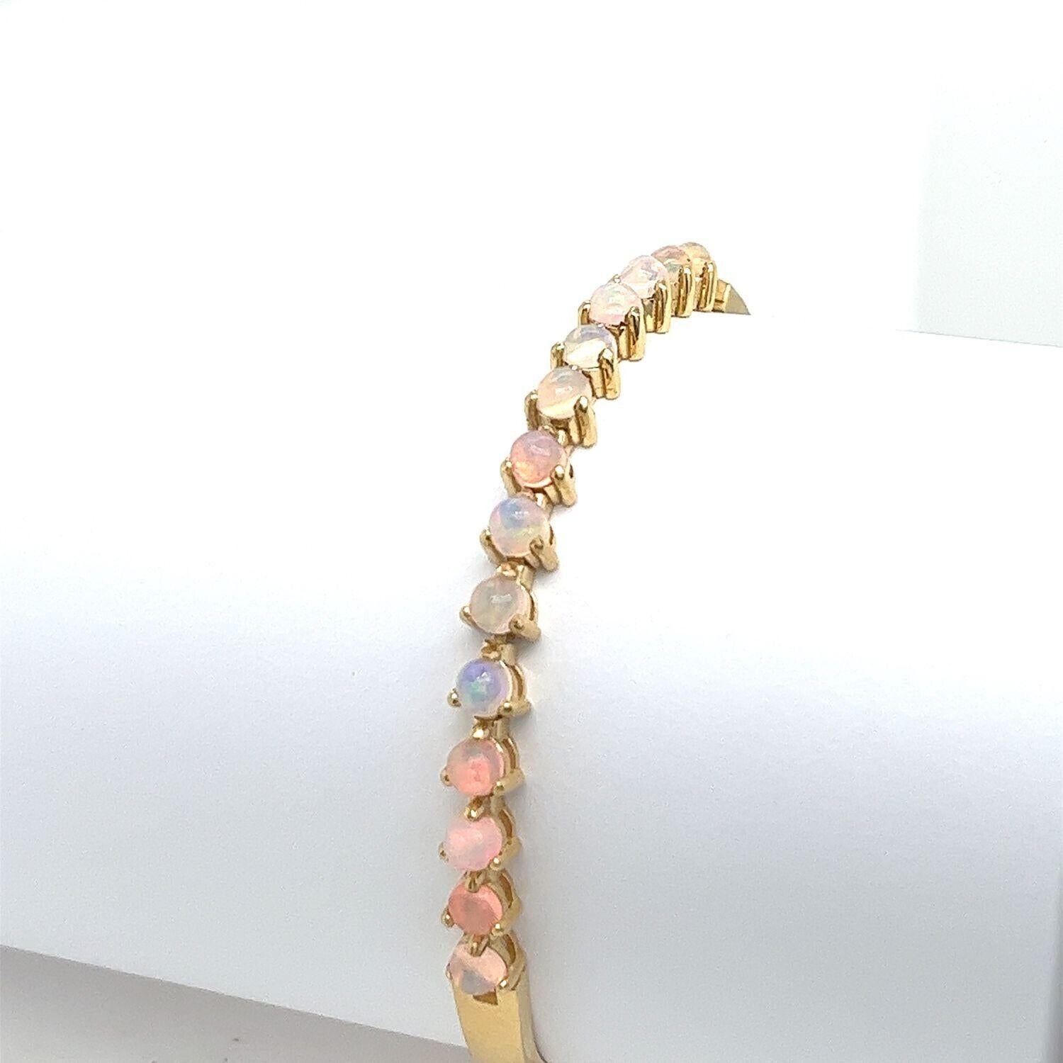 This bracelet is made of 18ct Yellow Gold and set with 14 round natural Opals, and has a beautiful finish. This design is ideal for everyday wear.

Additional Information:
This bracelet is made of 18ct Yellow Gold and set with 14 round natural