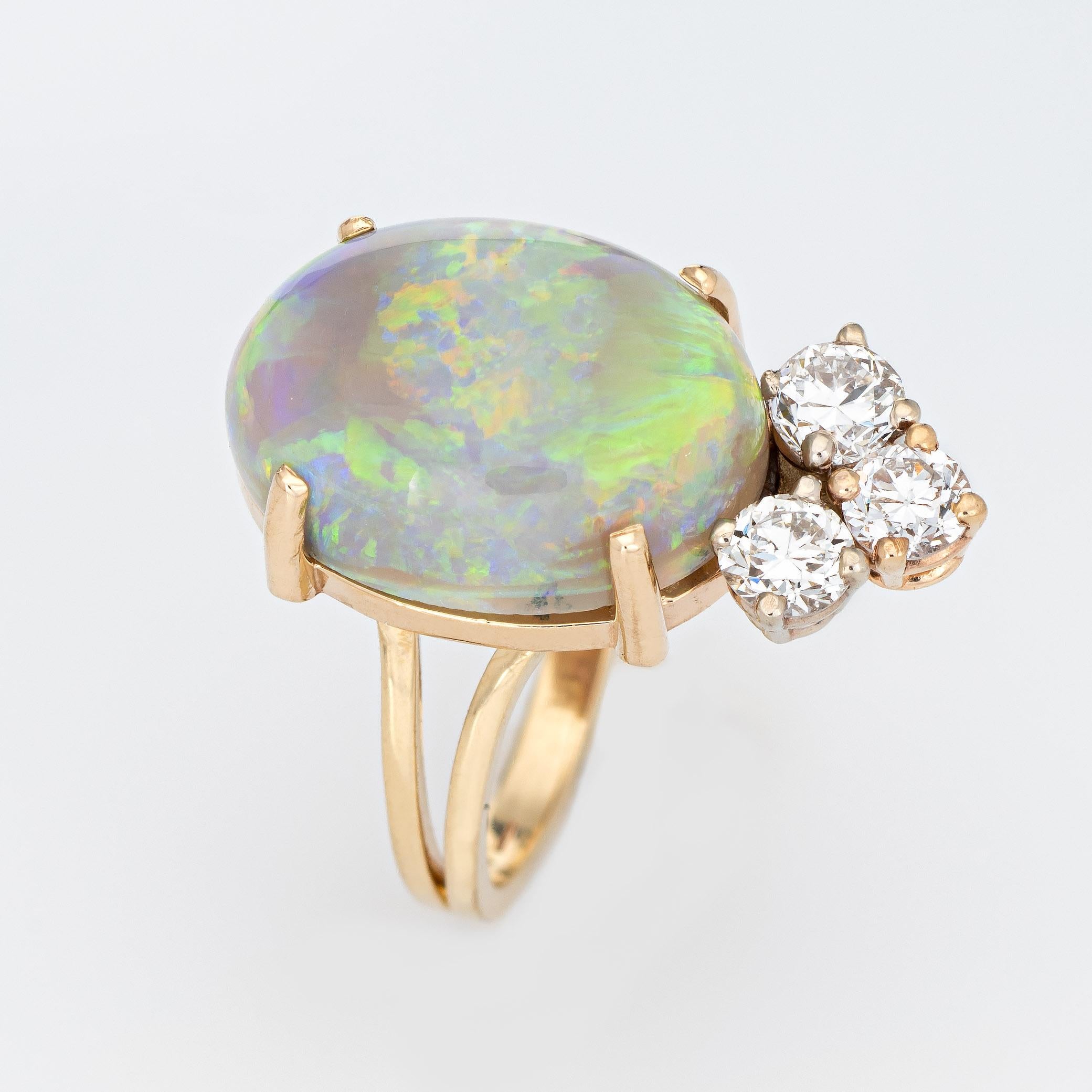 Stylish vintage opal & diamond cocktail ring crafted in 14 karat yellow gold. 

The natural opal measures 15mm x 11mm (estimated at 6.50 carats), accented with three estimated 0.15 carat round brilliant cut diamond. The total diamond weight is