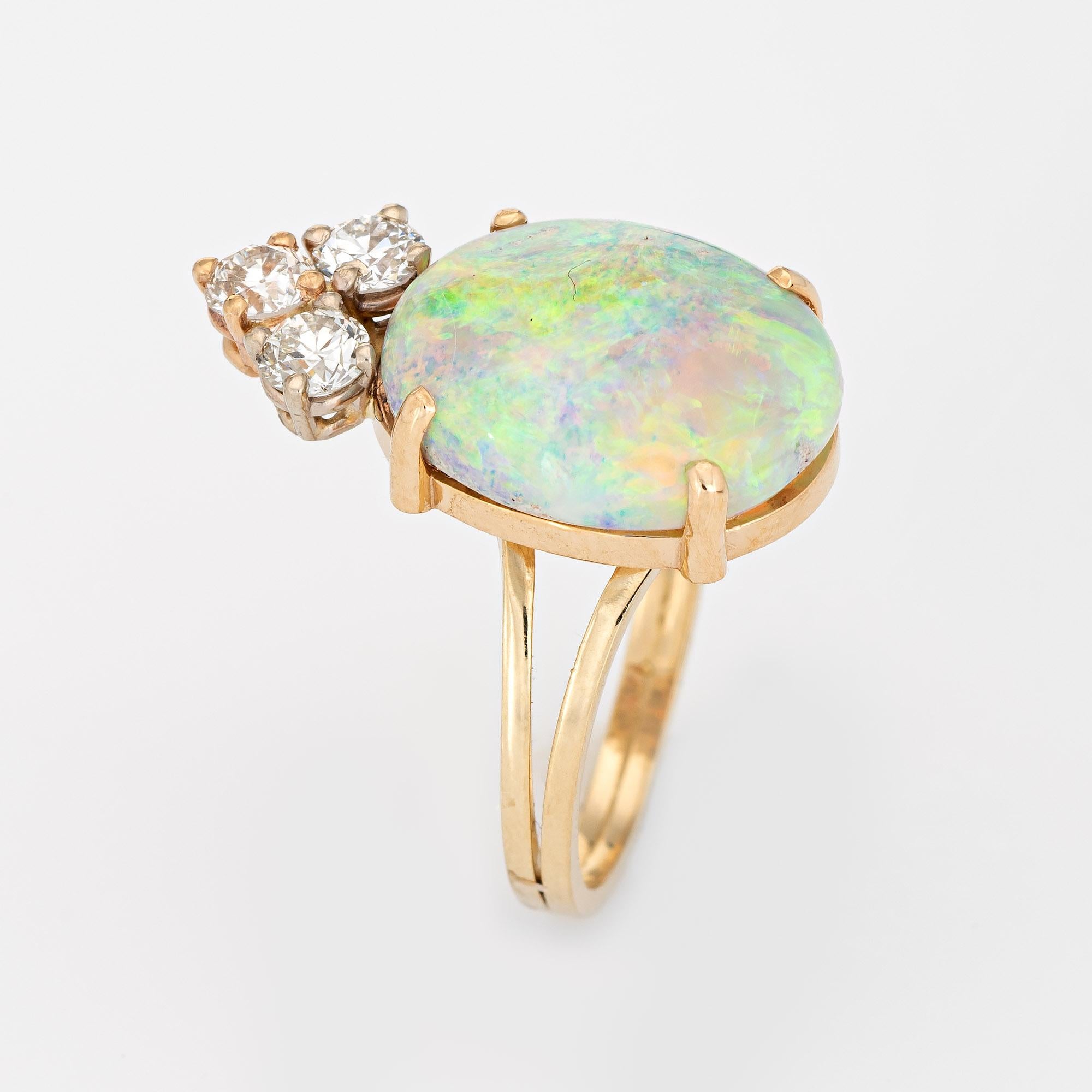 Stylish vintage opal & diamond cocktail ring crafted in 14 karat yellow gold. 

The natural opal measures 15mm x 11mm (estimated at 6.50 carats), accented with three estimated 0.15 carat round brilliant cut diamond. The total diamond weight is