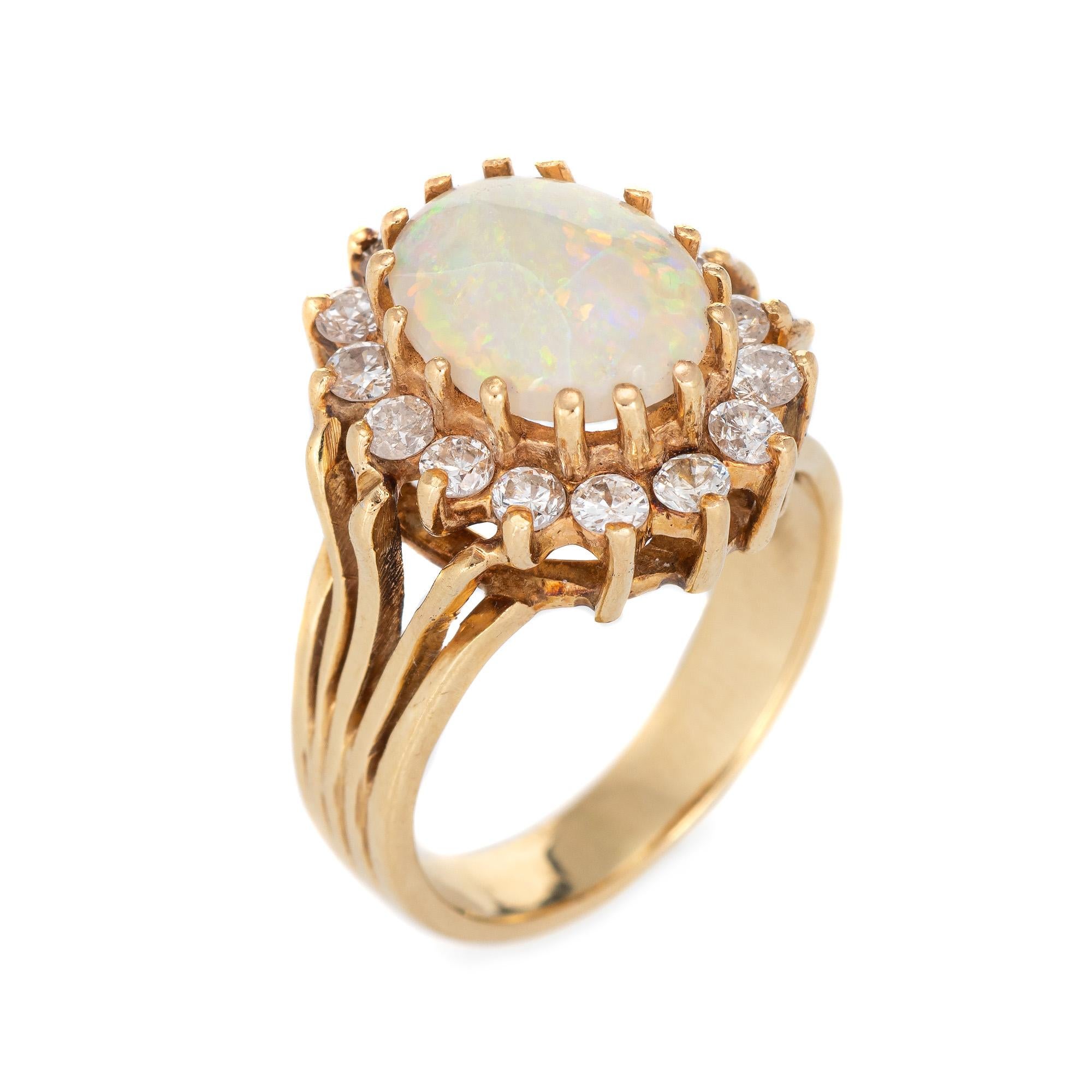Stylish vintage natural opal & diamond cocktail ring (circa 1970s to 1980s) crafted in 14 karat yellow gold. 

Cabochon cut natural opal measures 10mm x 7.8mm (estimated at 1.45 carats) is accented with an estimated 0.45 carats of diamonds