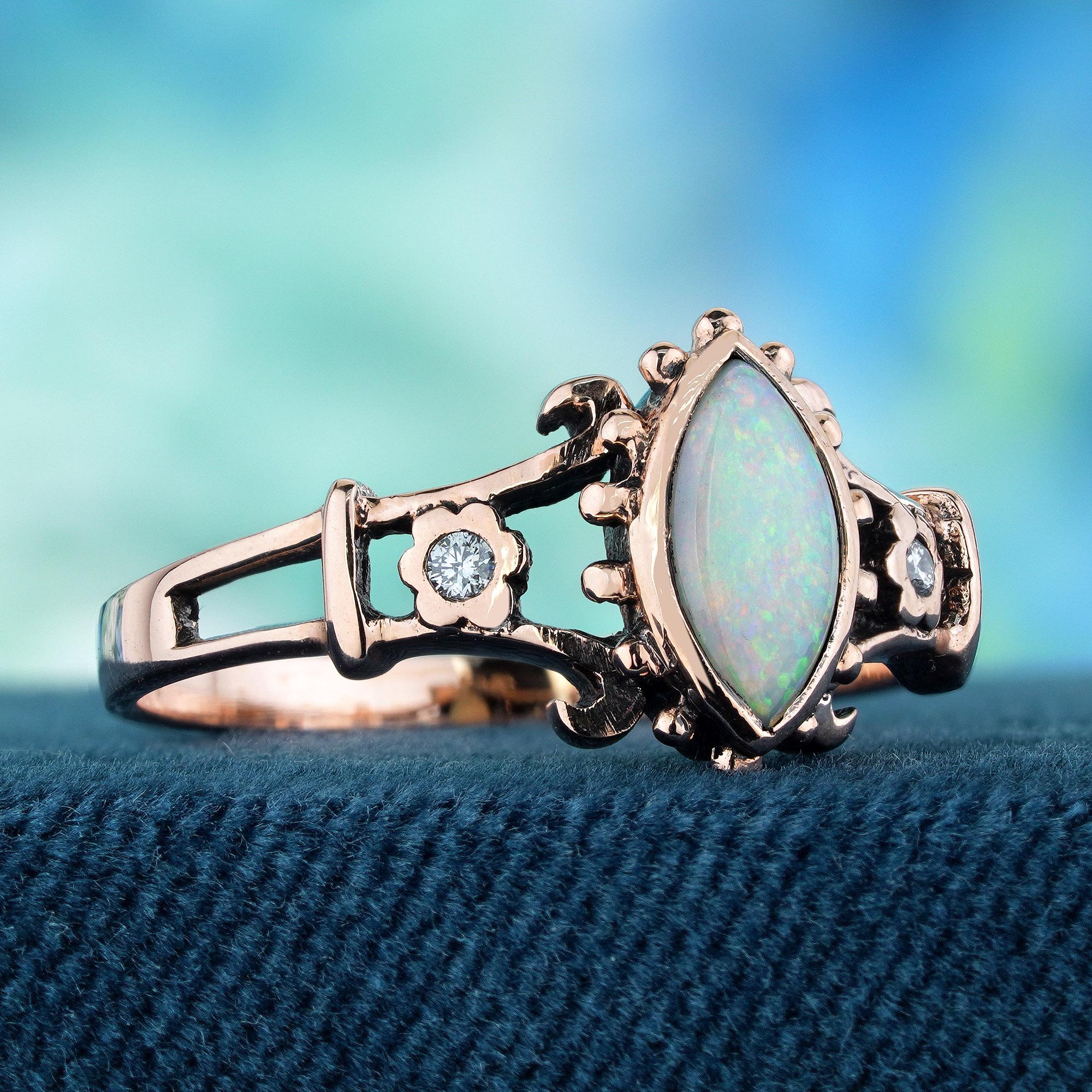 Adorn your hand with a delicate and unique touch through this vintage-style ring in rose gold. At its center, a marquise opal displays a fiery play-of-color, flanked on either side by a halo of small round diamonds in a small flower frames. The