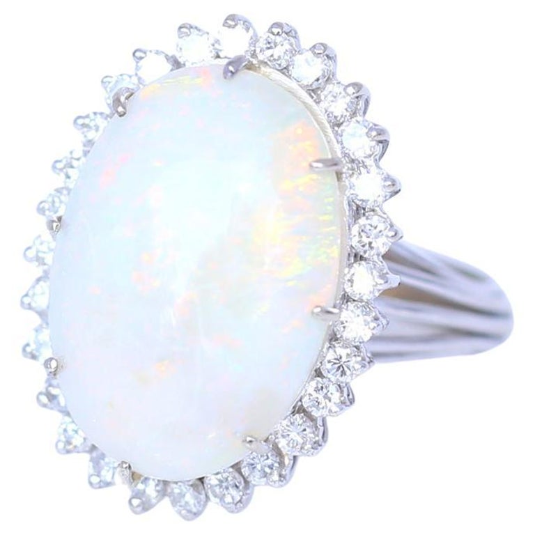Natural Opal Diamonds Ring. 
The 1950s, 14K gold. This classic fifties ring is all about the scintillating 15 Сarat cabochon opal. Displaying green, blue, orange, and red in varying hues, this stone has excellent fire and sublime play of light. 0.6