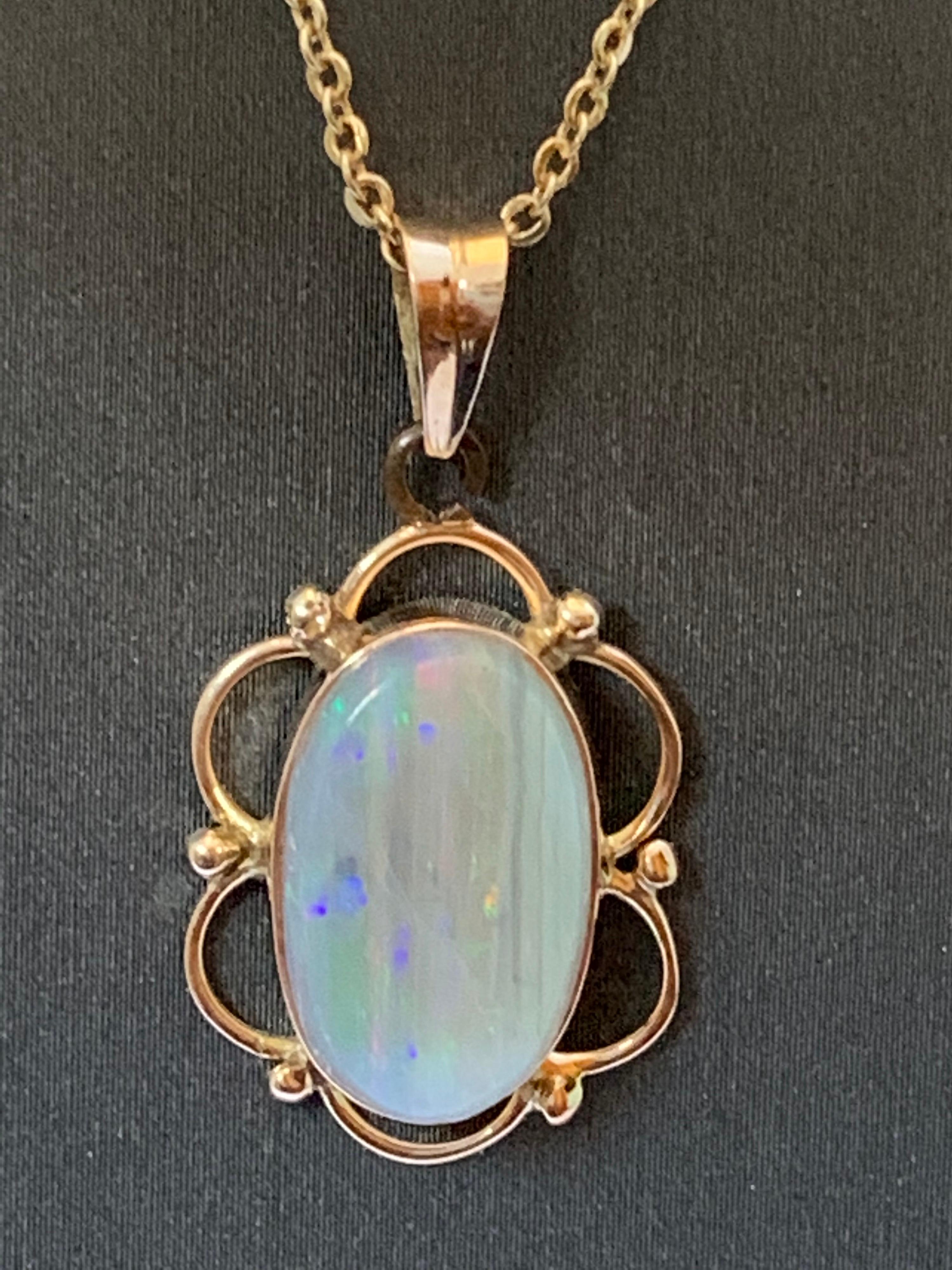 Ce pendentif de forme ovale de 8 mm x 14 mm est une opale naturelle sertie dans de l'or jaune 14 carats. L'opale est naturelle et multicolore (rouge, vert, bleu), ce qui peut être vu de l'avant et de l'arrière du pendentif. La pierre provient du Sri