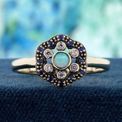 Anillo floral con ópalo natural, zafiro y zafiro blanco, en oro amarillo macizo de 9K