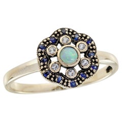 Anillo floral con ópalo natural, zafiro y zafiro blanco, en oro amarillo macizo de 9K
