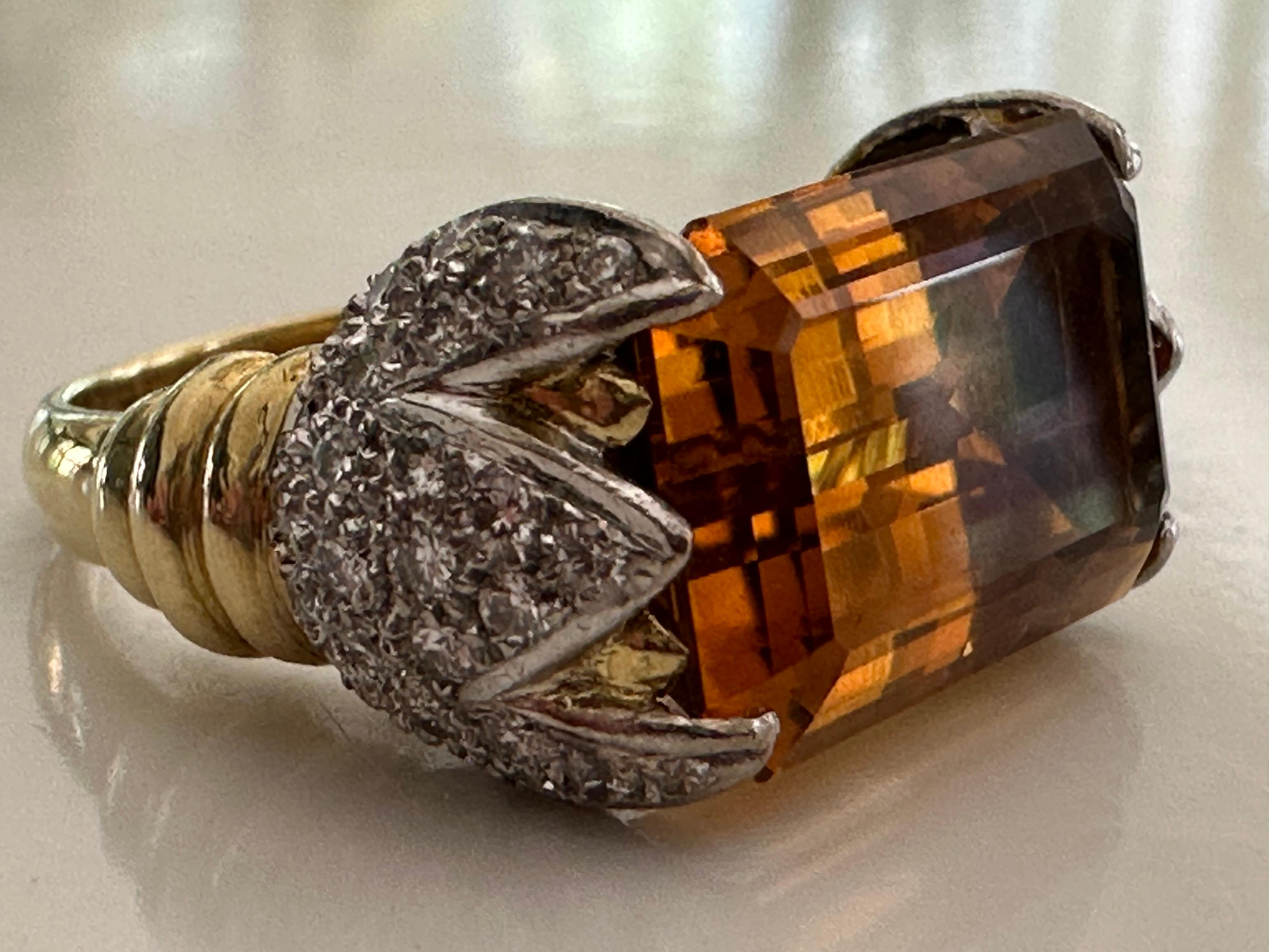 A large, emerald-cut natural orange citrine measuring 11 x 17.5mm in an East-West orientation highlights this exquisite cocktail ring accented with approximately 1.00 carat of round diamonds which adorn each shoulder in a claw-like design, GH color,