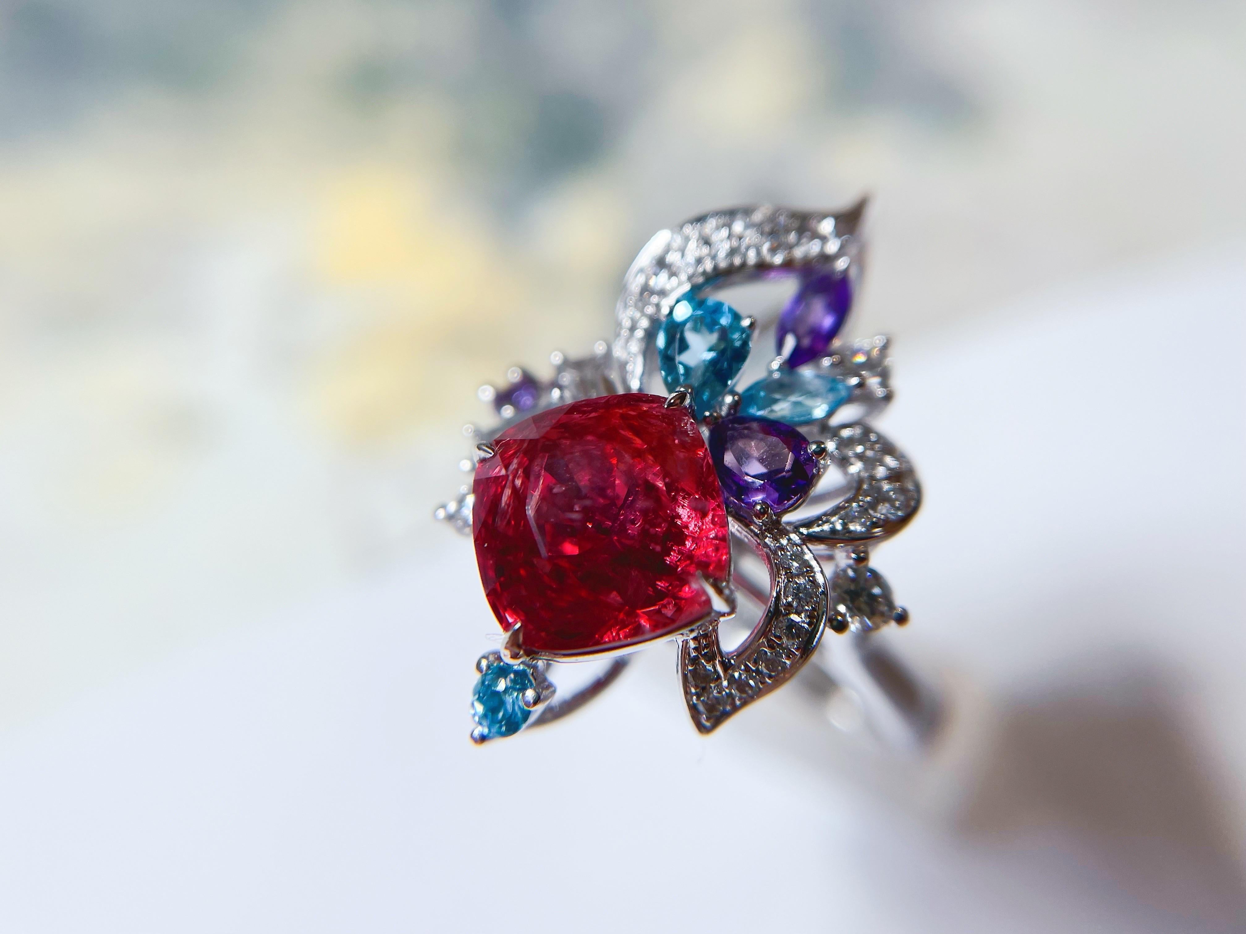 Dieser atemberaubend schöne rote Spinell hat über 3 Karat. Begleitet von glänzenden Amethysten, Topasen und Diamanten sind dieser individuell gestaltete Ring und Anhänger einfach einzigartig und unverwechselbar. Die ausgefallene Farbkombination aus
