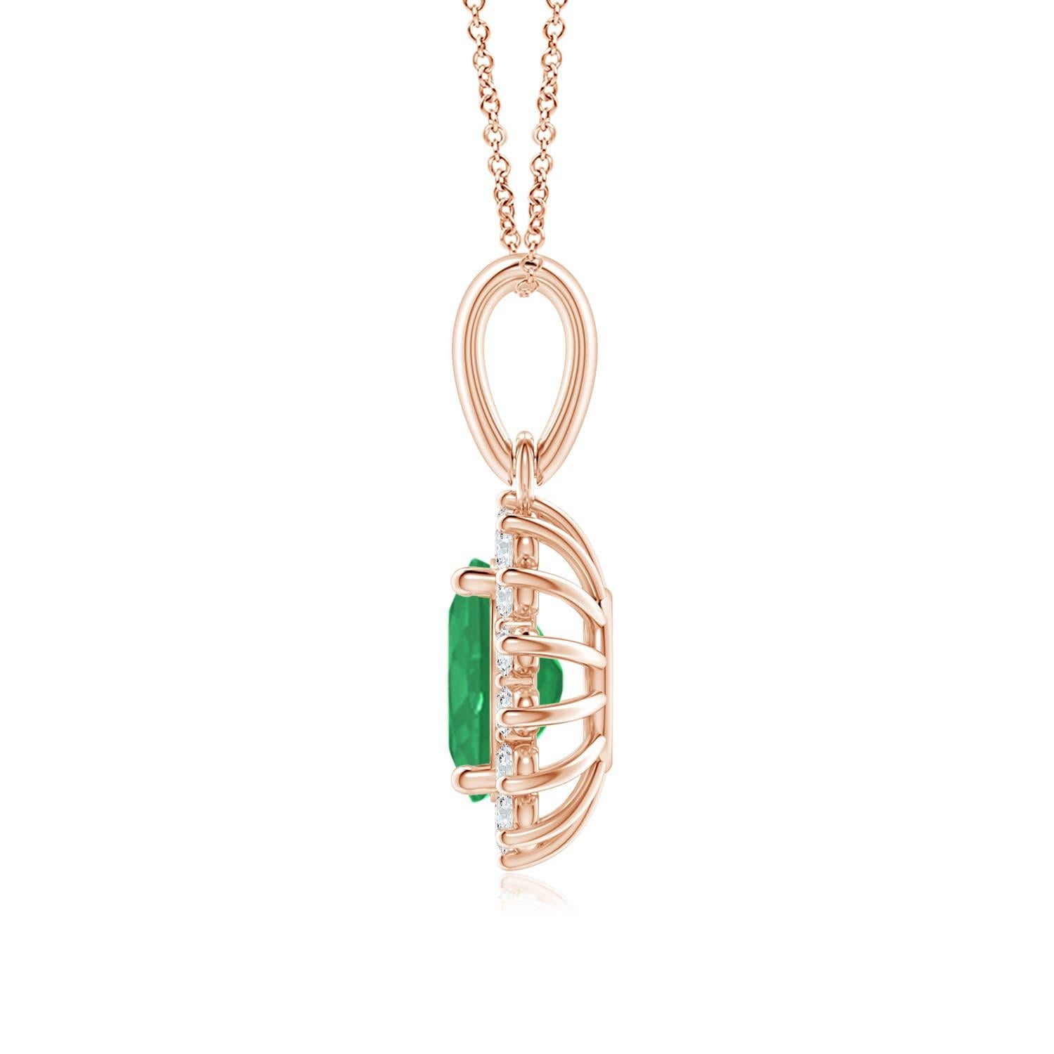 This enchanting emerald and diamond halo dangle pendant will steal hearts with its exquisiteness. An oval lush green emerald at the center is surrounded by sparkling white diamonds to create a beautiful floral design. Sculpted in 14k rose gold, this