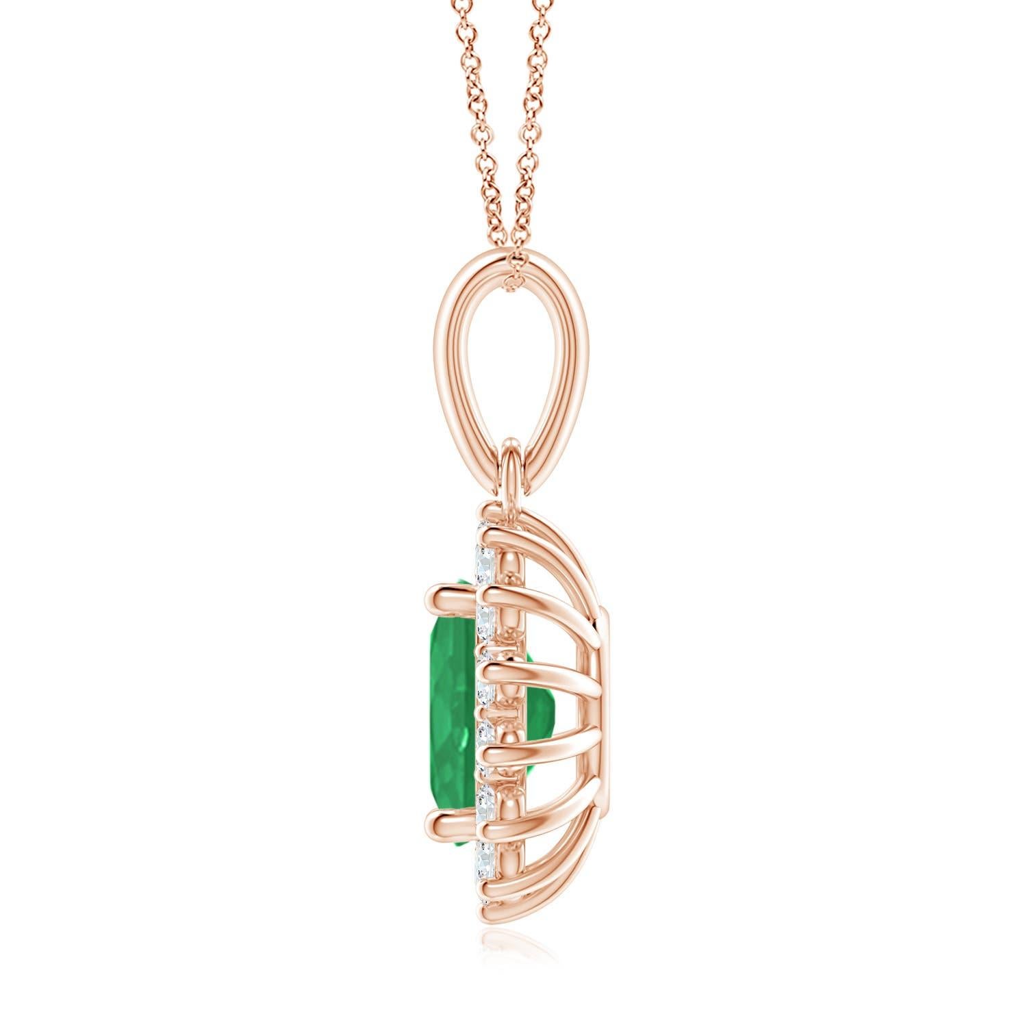 This enchanting emerald and diamond halo dangle pendant will steal hearts with its exquisiteness. An oval lush green emerald at the center is surrounded by sparkling white diamonds to create a beautiful floral design. Sculpted in 18k rose gold, this