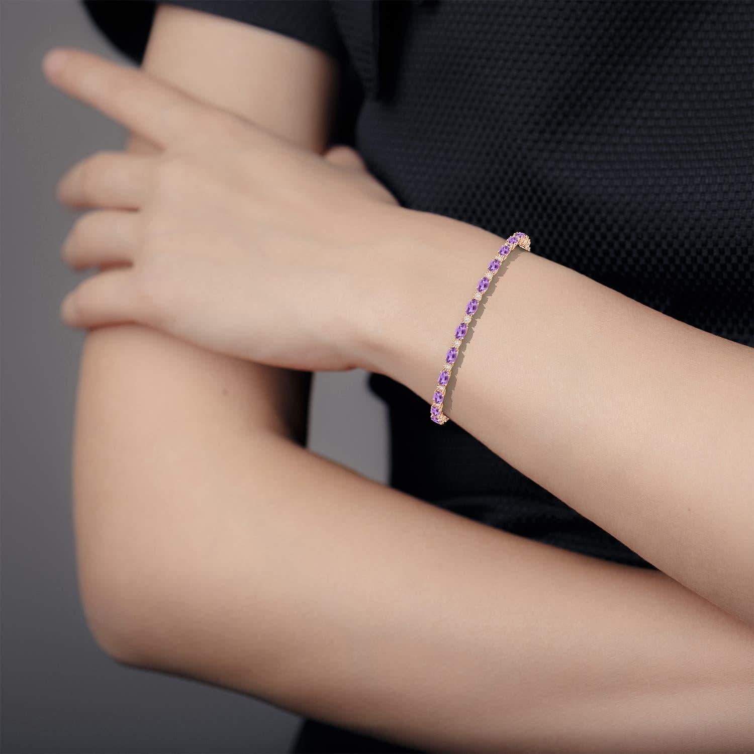 Ce bracelet de tennis en améthyste ovale est réalisé en or rose 14k. Des diamants d'illusion étincelants, sertis de manière gitane, sont combinés avec les pierres violettes royales et créent un effet luxueux.