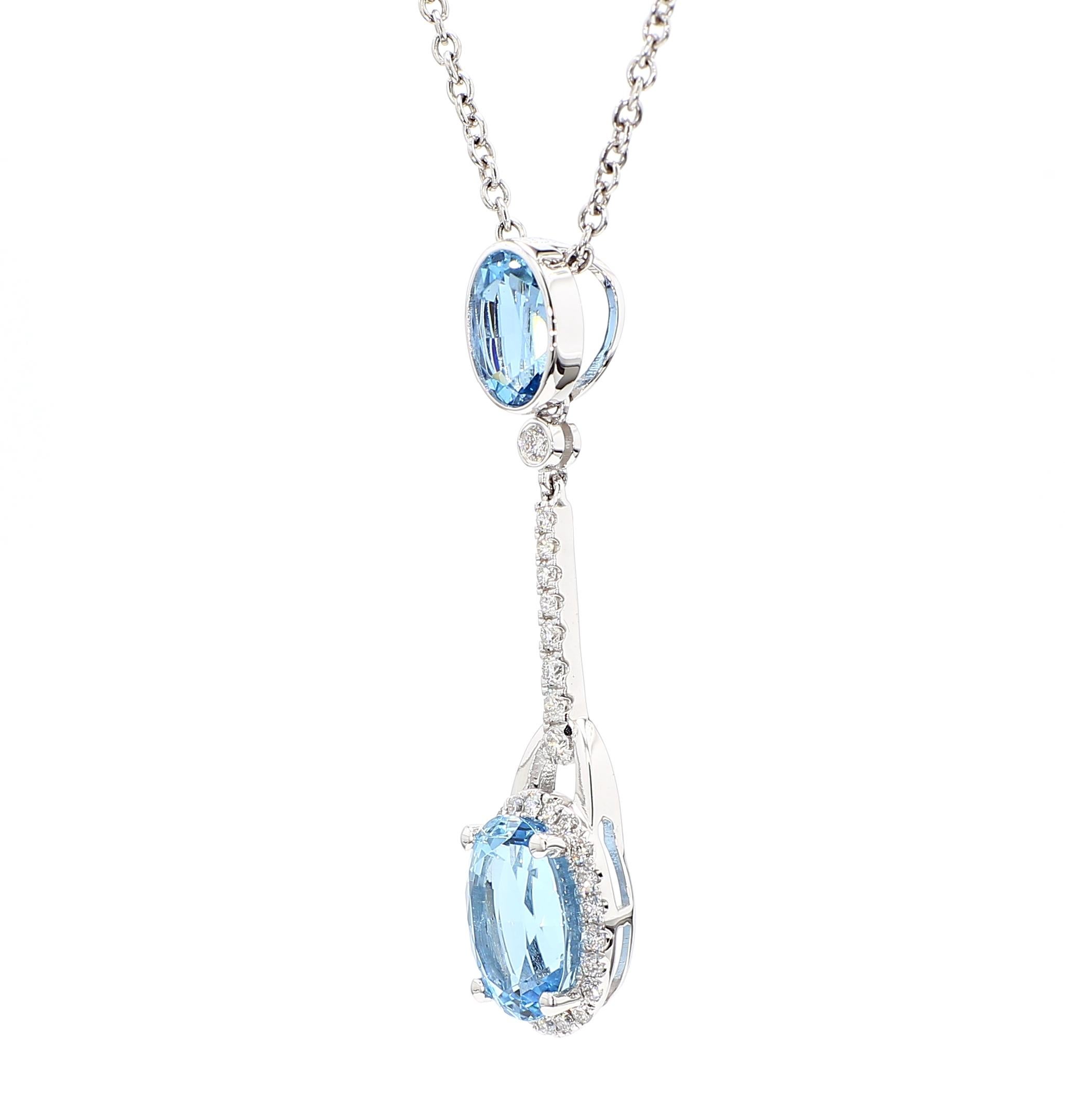Il bellissimo ciondolo di acquamarina di RareGemworld. Montato in una splendida montatura in oro bianco 14 carati con due acquamarine naturali dal taglio ovale circondate da diamanti bianchi naturali rotondi. Questo ciondolo è destinato a stupire e