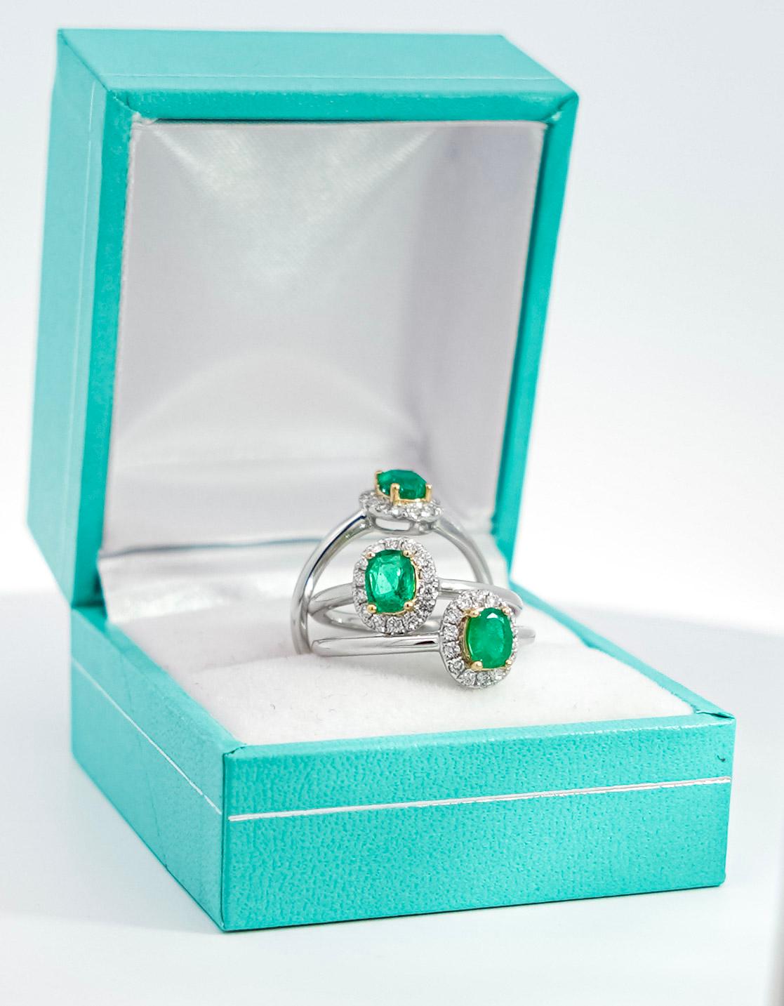 Natural Green Emerald and Natural Diamond Ring, Set in 18K Solid White Gold. The perfect natural gemstone emerald ring that doesn't break the bank.

Featuring a vivid oval cut green natural Emerald and round cut diamond side stones that form a halo.