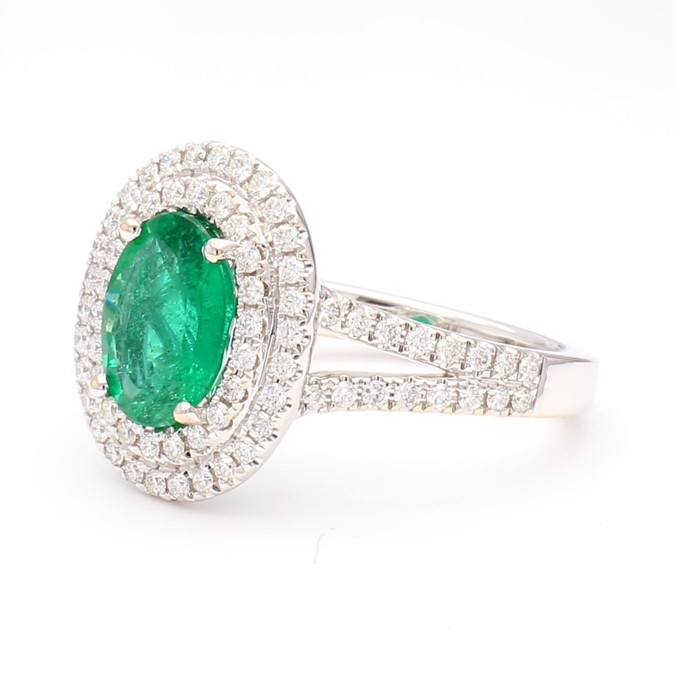 RareGemWorld's beautiful emerald ring. Mounted in a beautiful 18K White Gold setting with a natural oval cut emerald. The emerald is surrounded by natural round white diamond melee. This ring is guaranteed to impress and enhance your personal