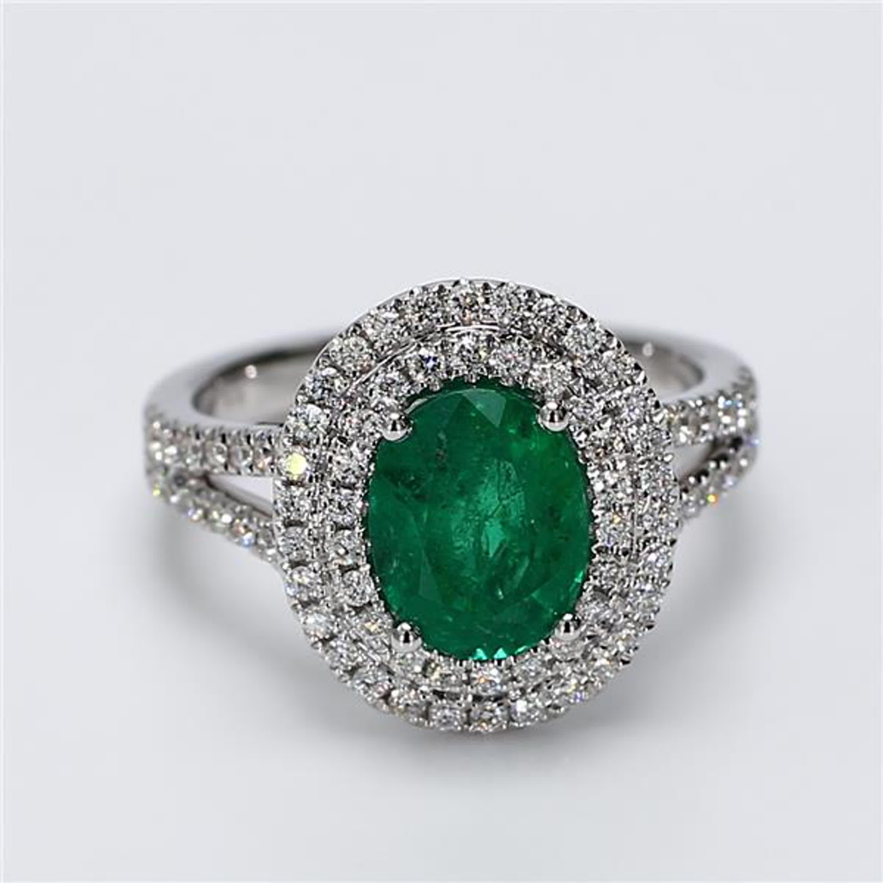 RareGemWorld's classic emerald ring. Mounted in a beautiful 18K White Gold setting with a natural oval cut emerald. The emerald is surrounded by natural round white diamond melee. This ring is guaranteed to impress and enhance your personal