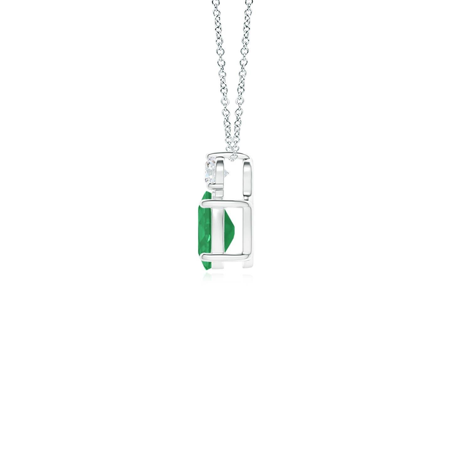 Dieser klassische Solitär-Smaragd-Anhänger aus 14-karätigem Weißgold verkörpert Eleganz. Der sattgrüne ovale Smaragd wird von einem funkelnden Diamanten gekrönt, der für zusätzlichen Reiz sorgt. Die verschlungenen Schnörkel an den Seiten