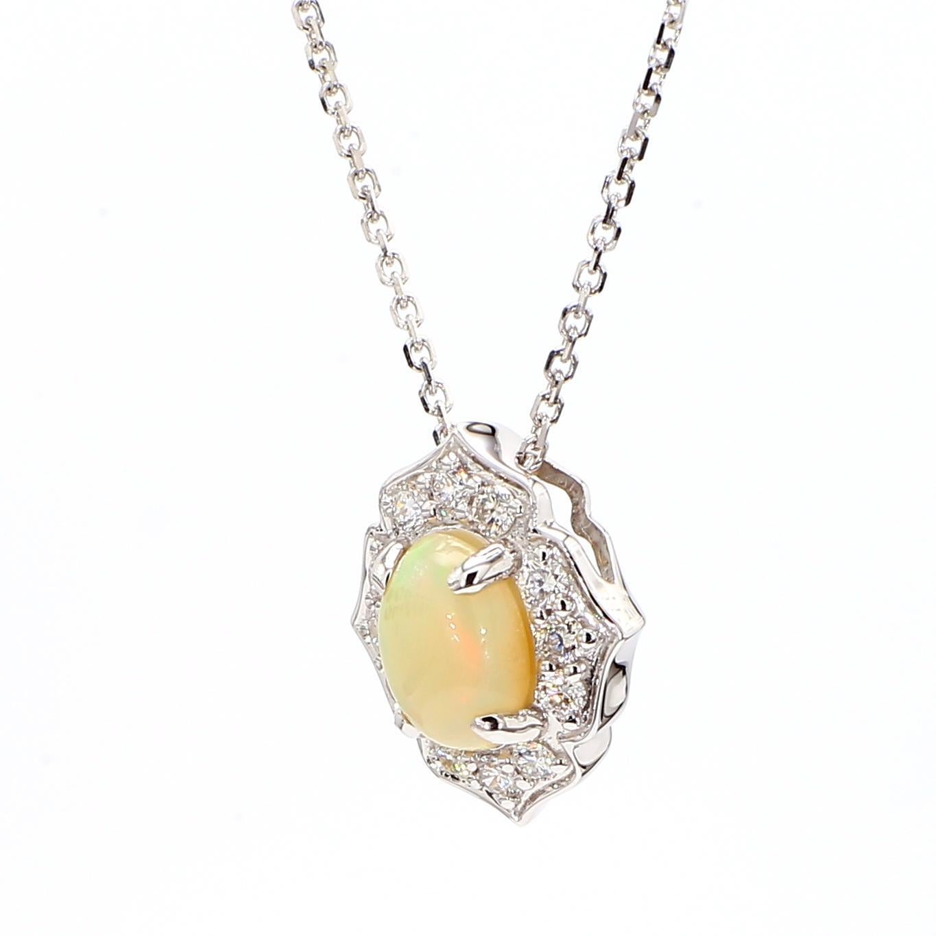 Le magnifique pendentif en opale de Raregemworld. Montée dans une belle monture en or blanc 18 carats avec une opale naturelle de taille ovale complétée par une mêlée de diamants blancs de taille ronde. Ce pendentif est garanti pour impressionner et