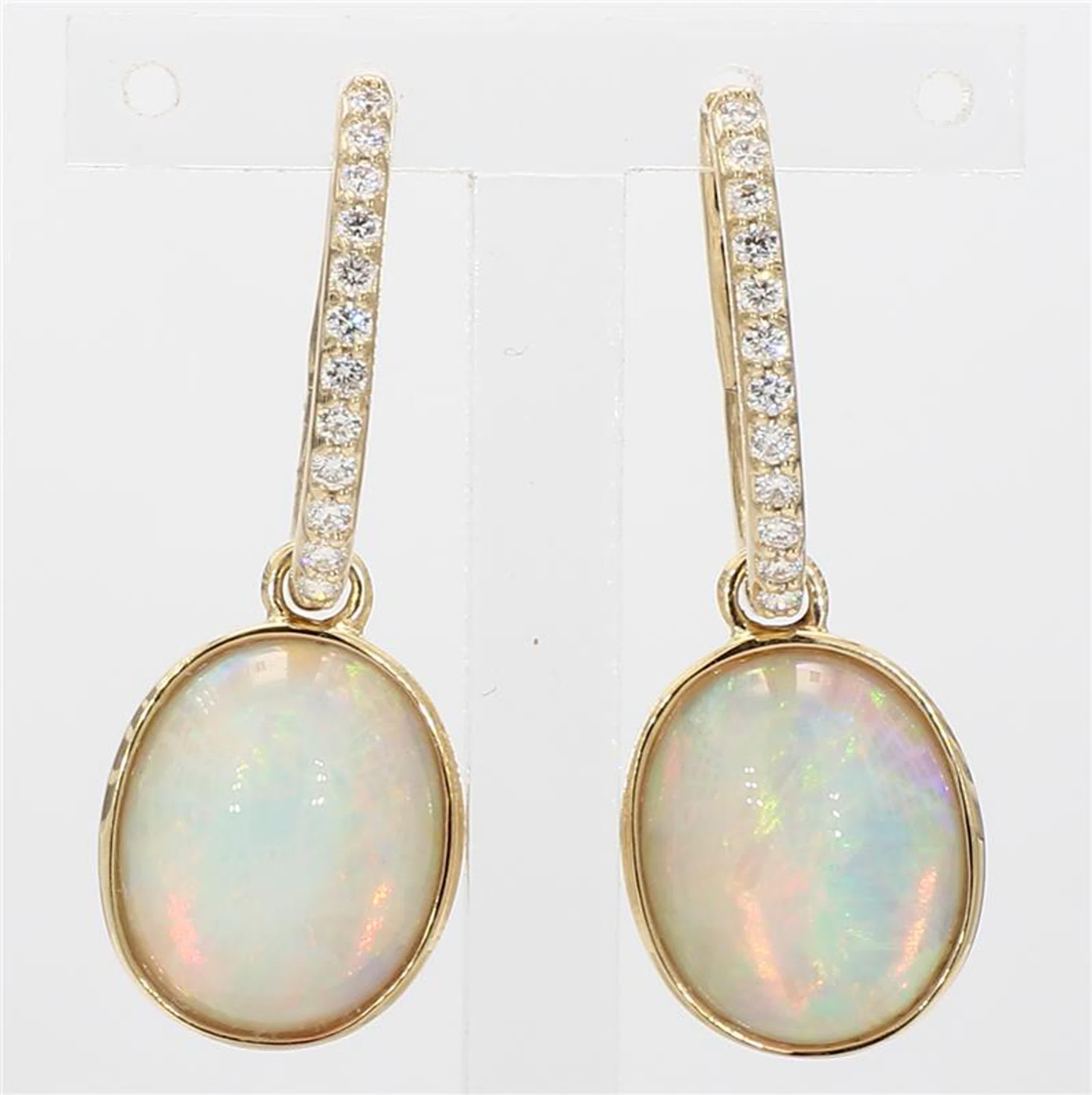 RareGemWorld's classic opal earrings. Mounted in a beautiful 14K Yellow Gold setting with natural oval cut opal's. The opal's are surrounded by natural round white diamond melee. These earrings are guaranteed to impress and enhance your personal