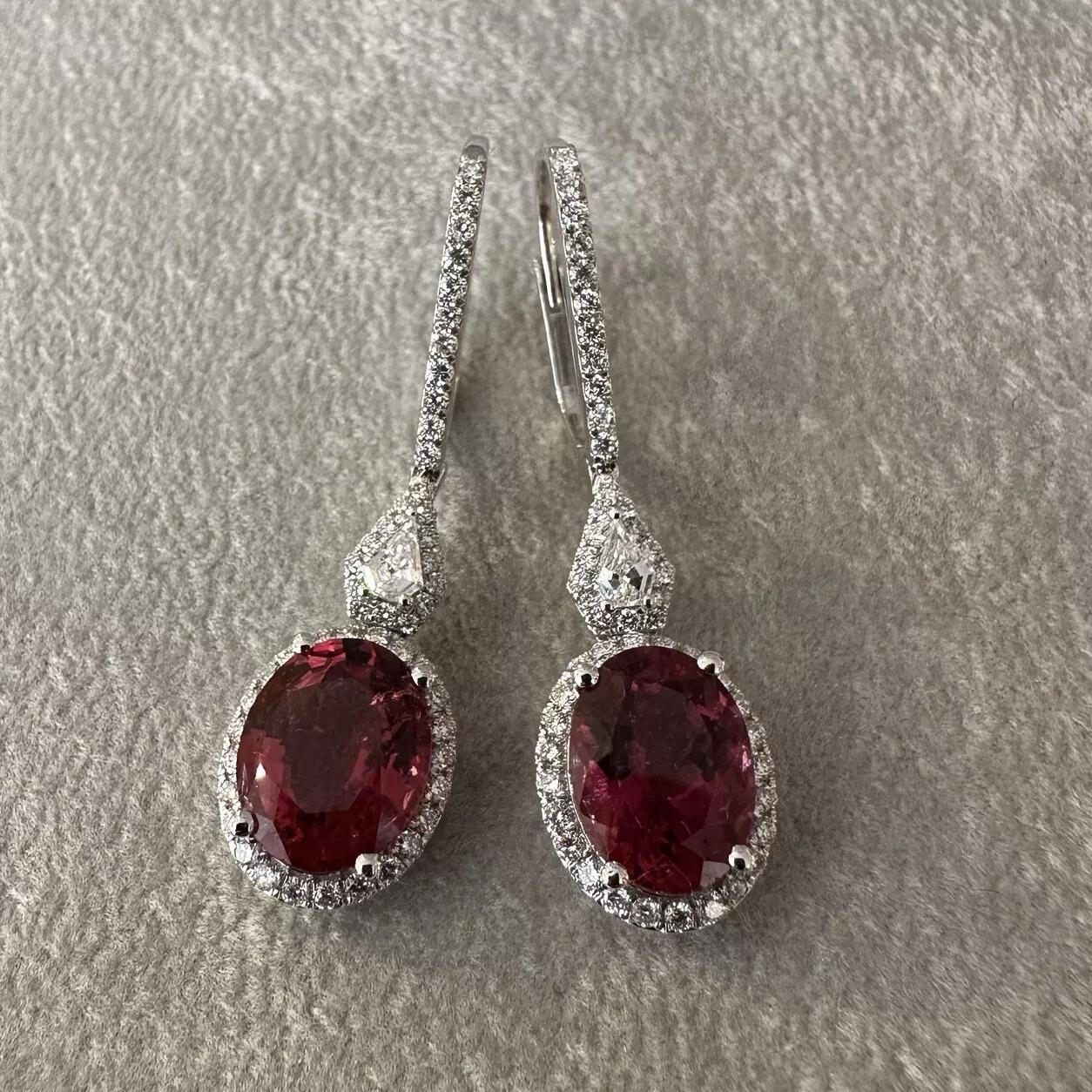 Natural Oval Rubellite and Diamond Drop Earrings in 18k White Gold 

Rubellite and Diamond Earrings features natural Oval Rubellites surrounded by Round Brilliant Diamonds and topped with Shield cut and Round Diamonds, all set in 18k White Gold. The