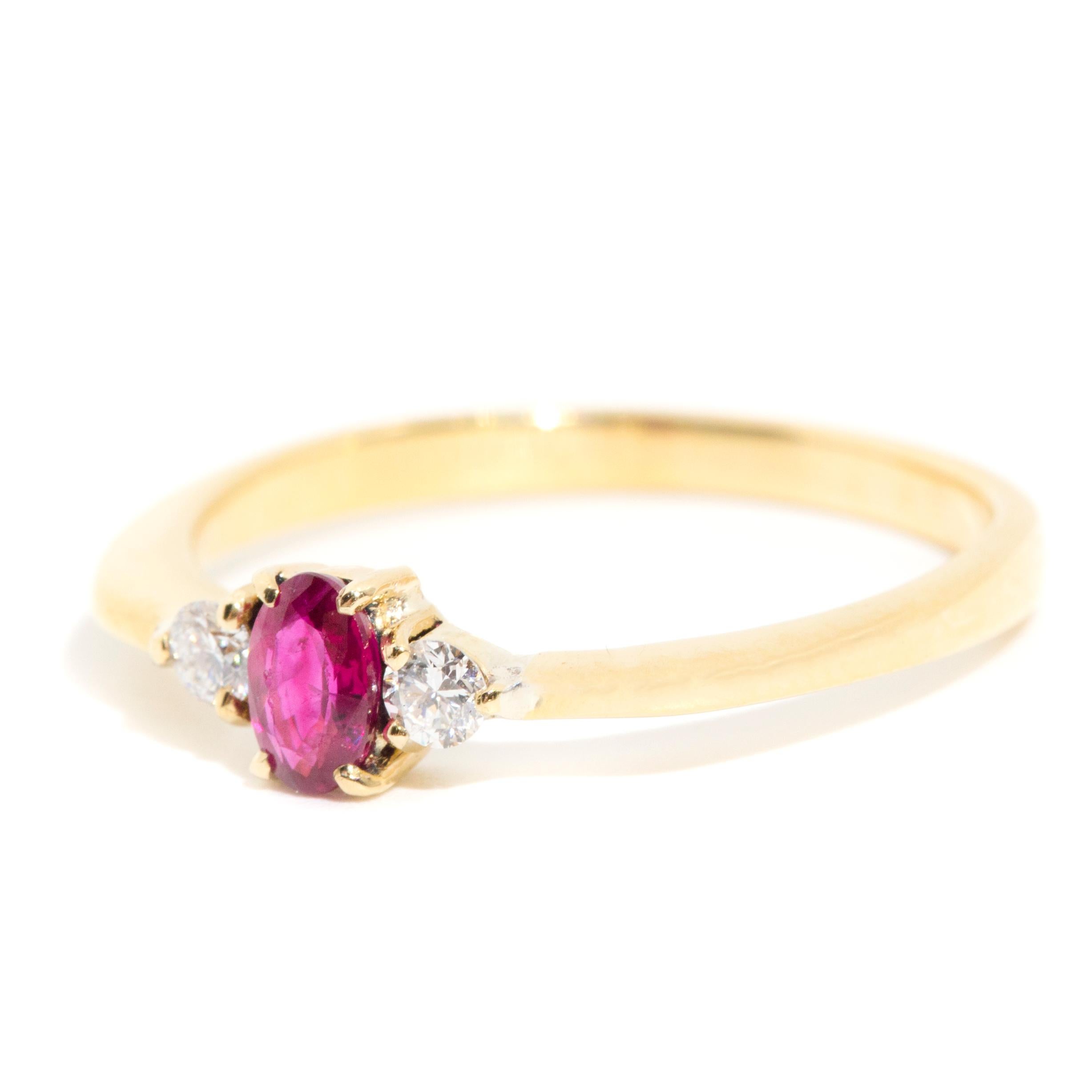 Carefully crafted in 14 carat yellow gold is this three stone vintage ring featuring one bright red oval natural Ruby flanked with two darling round brilliant cut diamonds. We have named this charming vintage ring The Tyla Ring. The Tyla Ring
