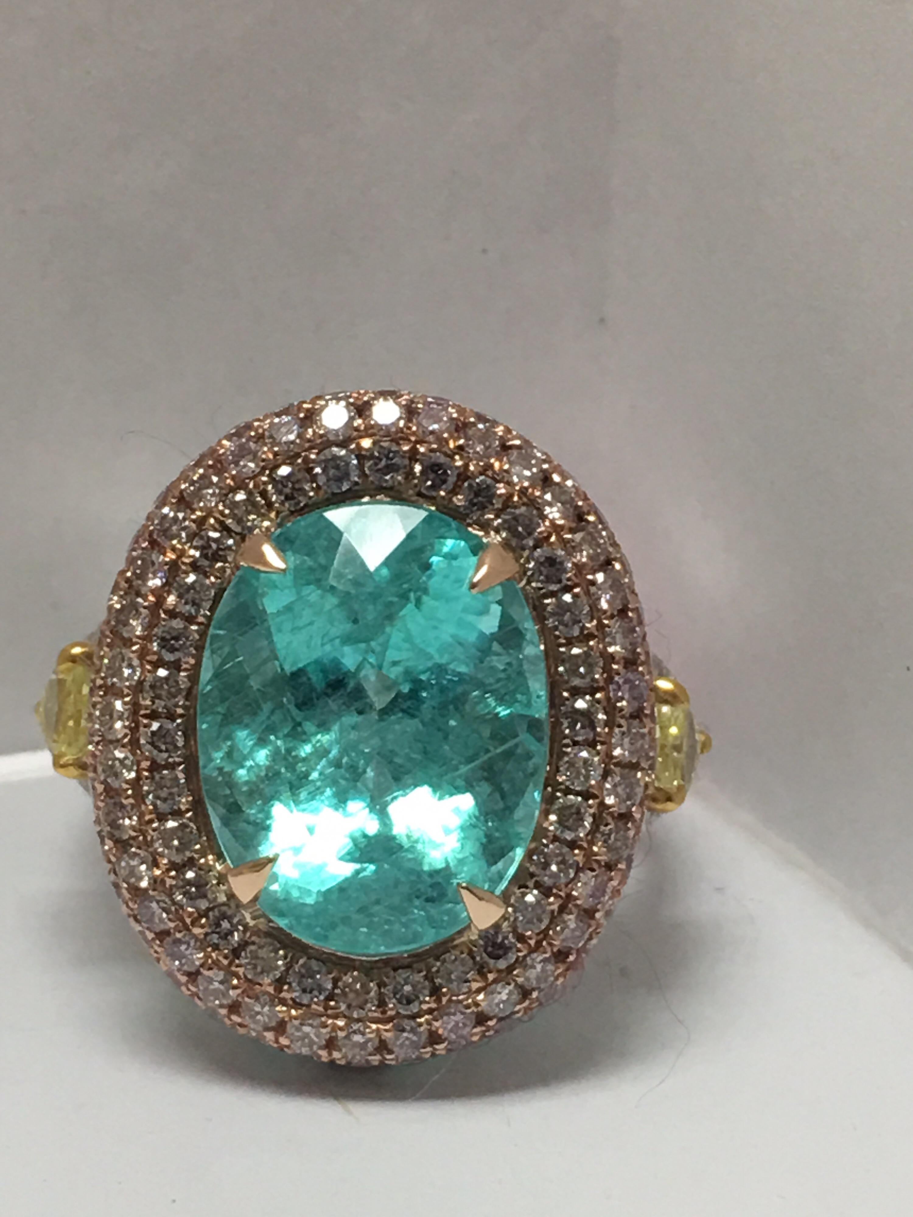 Natural 8.14 Carat Paraiba Tourmaline set with 0.52 Carat Intense Yellow Pear shape diamond,Pink Diamonds Halo 1.19 Carat and other white diamonds 0.26 Carat set in 18K three tone gold is size 7 ring and can be resize if needed.