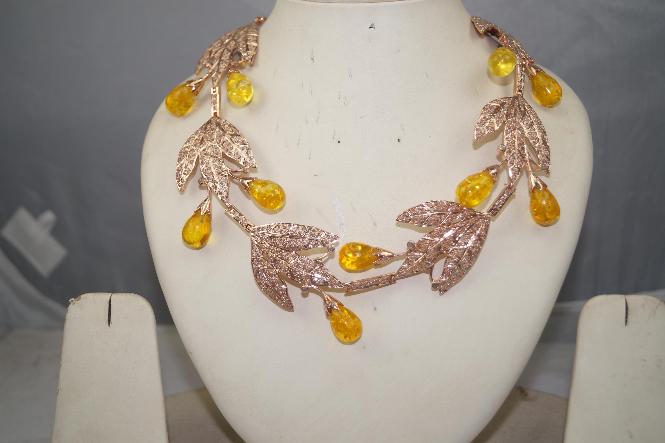 This unique piece of art is a beautiful accessory by the fine artisans. This jewel is made up of sterling silver jewel with natural pave diamonds and amber drops. The metal has rose gold plating over it. 

It is a convertible jewel that can be worn