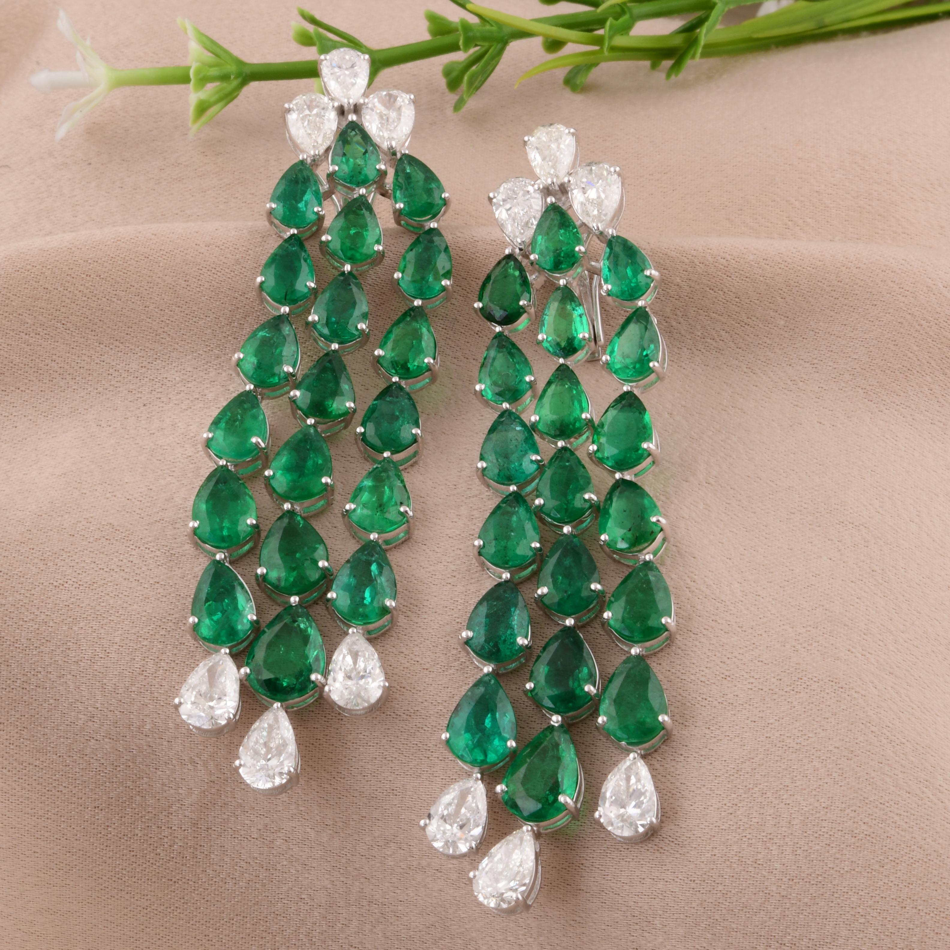 Elevate your style to the pinnacle of sophistication with these breathtaking Pear Zambian Emerald Gemstone Chandelier Earrings, adorned with shimmering Diamonds and meticulously crafted in lustrous 14 Karat White Gold. This stunning pair of earrings