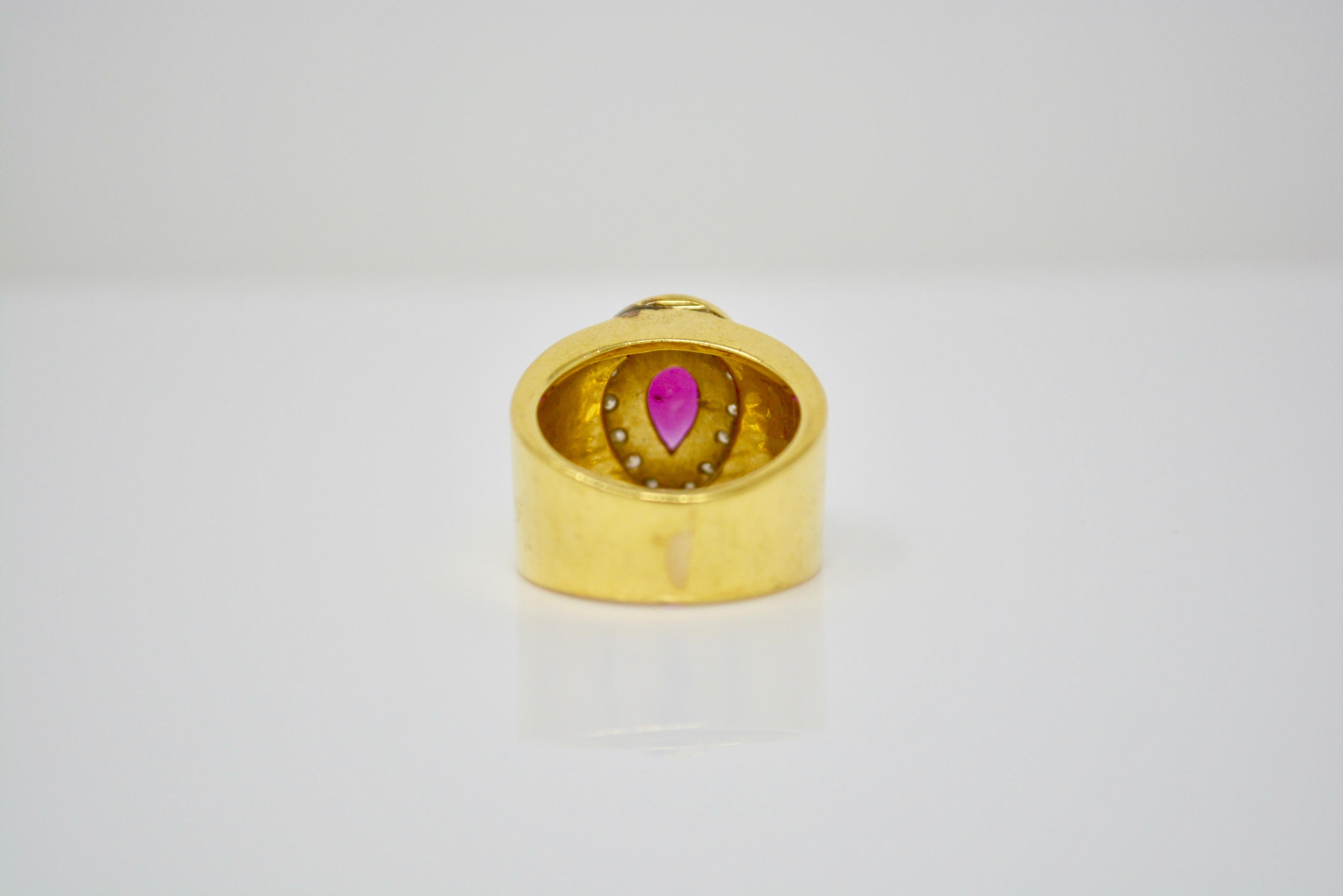 This unique and beautiful cocktail ring is set with a pear shape ruby weighing 0.70 carat approximately with a white small diamond surround. This is hand made in 18 k yellow gold and the size of the ring is 5 1/4.